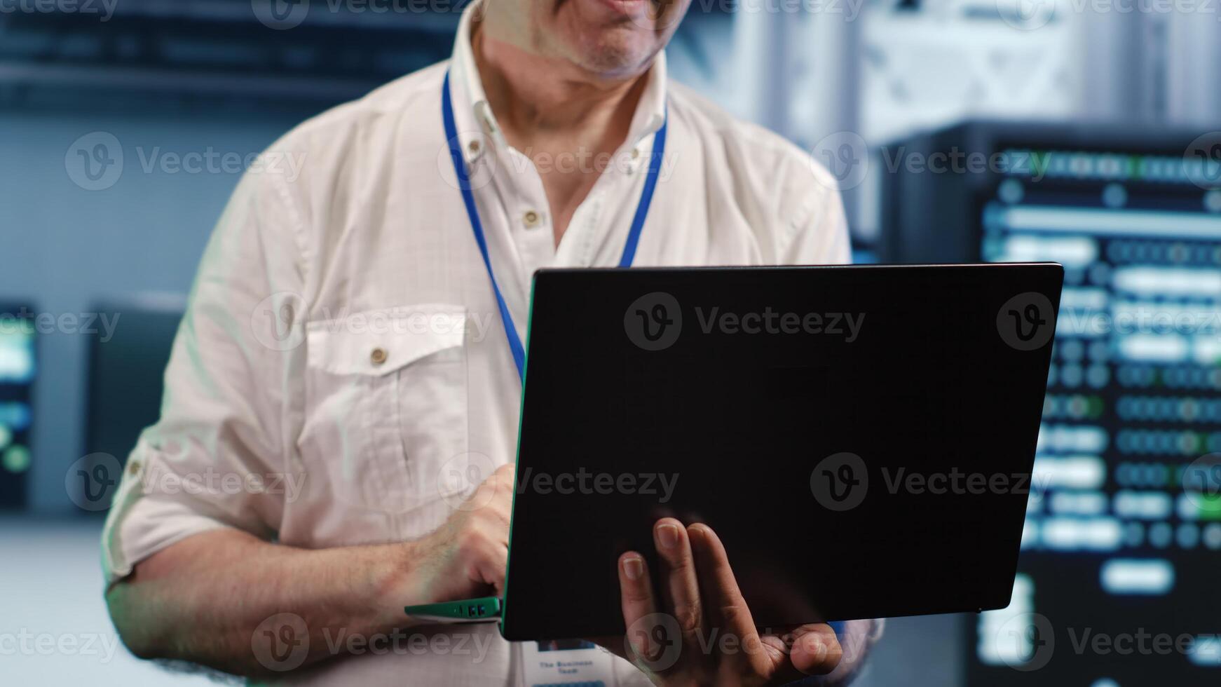 Aged developer expertly managing data while navigating in industrial server hub. Older programmer ensuring ideal cybersecurity protection, optimizing systems, close up photo