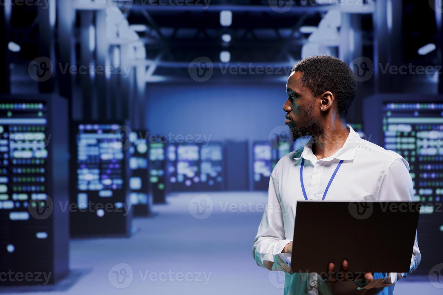 Computer scientist strolling amidst data storage devices in server room, ensuring proper operational conditions. Repairman closely monitoring energy consumption of high tech facility infrastructure photo