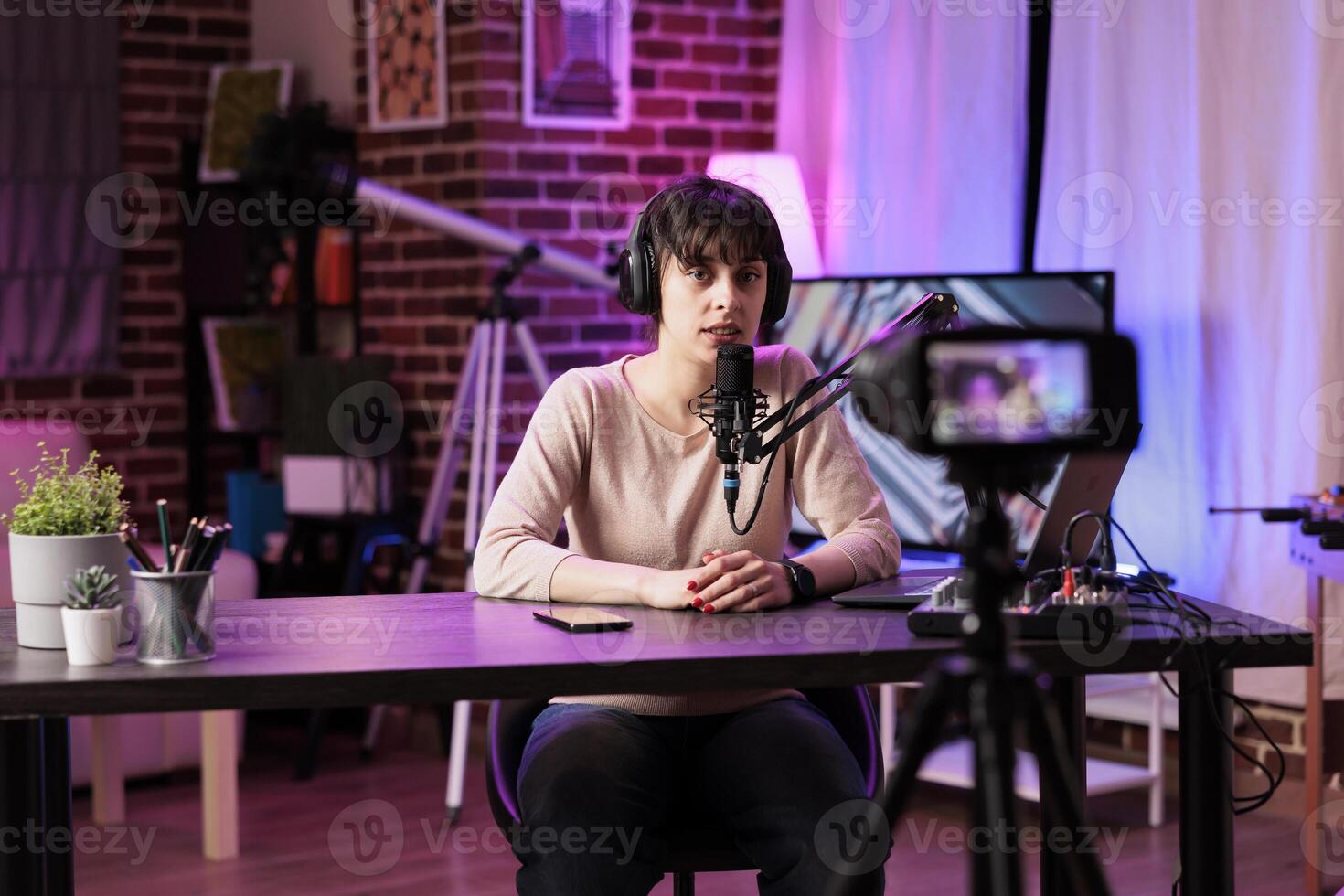 Vlogger recording internet show using modern camera, talking about business and finance subjects. Influencer filming live broadcast for her fans using professional equipment photo