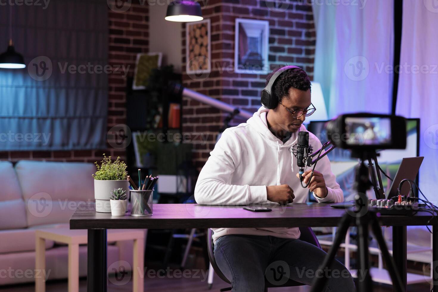 Vlogger recording internet show using modern camera checking comments left by fans. Man filming content for online vlog, reading remarks left by supporters on his channel videos photo