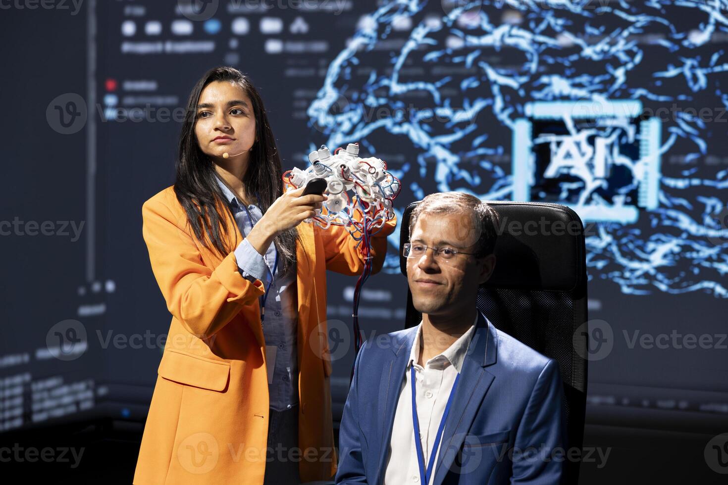 Company CEO using summit as platform to launch latest AI EEG headset product. Neuroscientist doing demonstration at forum in front of business leaders interested in artificial intelligence photo