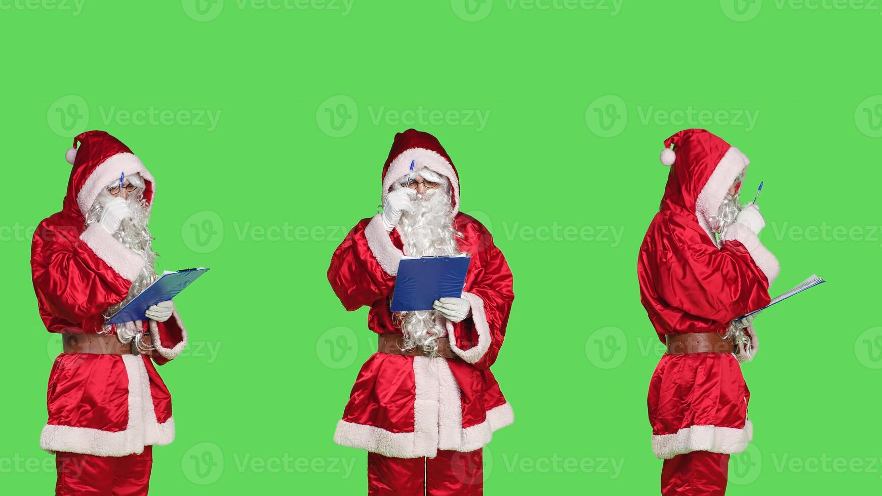 Adult in saint nick costume using papers on clipboard to create naughty and nice list, christmas eve concept. Santa claus checking to see gifts and presents, standing on greenscreen backdrop. photo