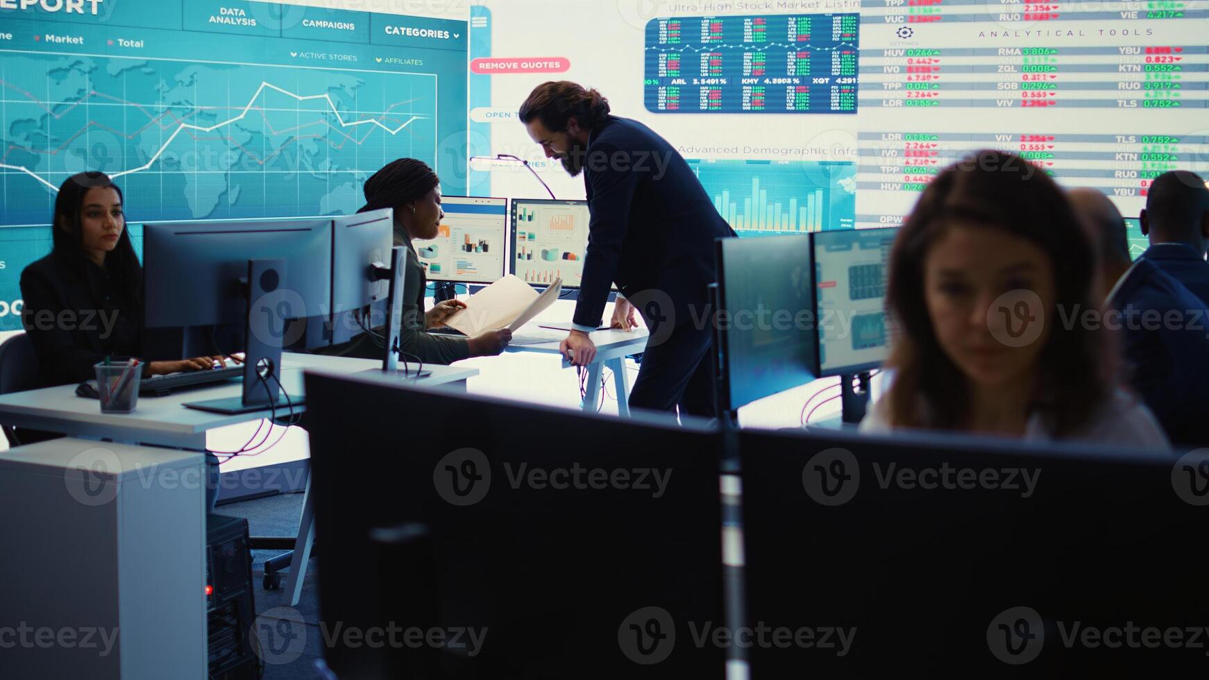 Marketing specialist studying infographics on computer in a monitoring room with big screen, check customer satisfaction from annual data reports. Employee review performance metrics. Camera B. photo