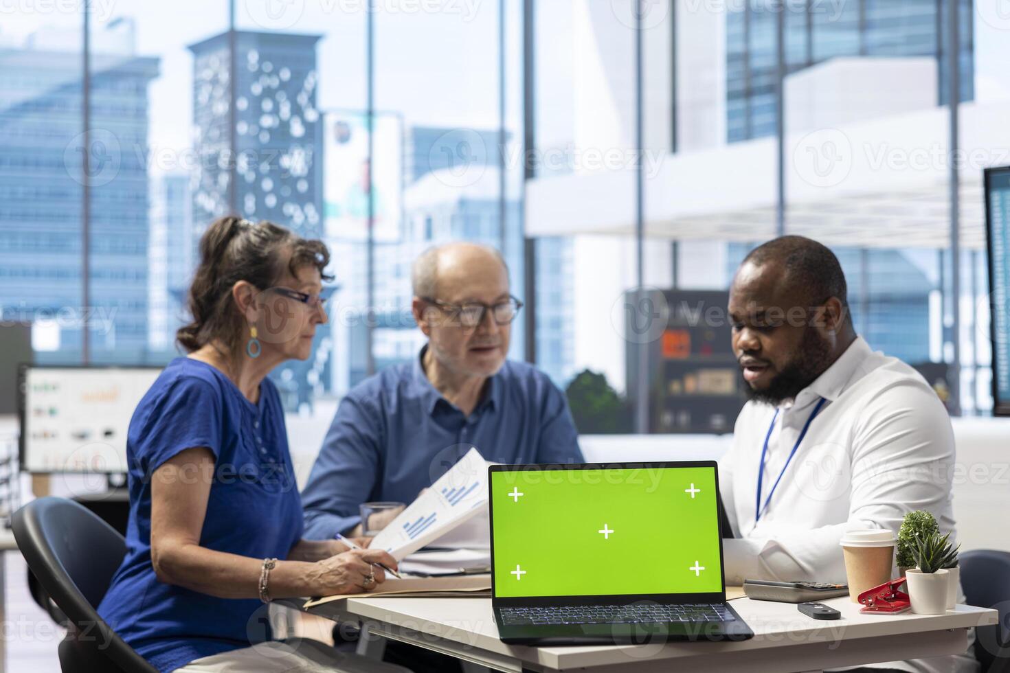 Broker helping old couple with retirement plans options at a financial counseling meeting, working with chroma key display. Elderly couple asking insurance expert about financial options. photo