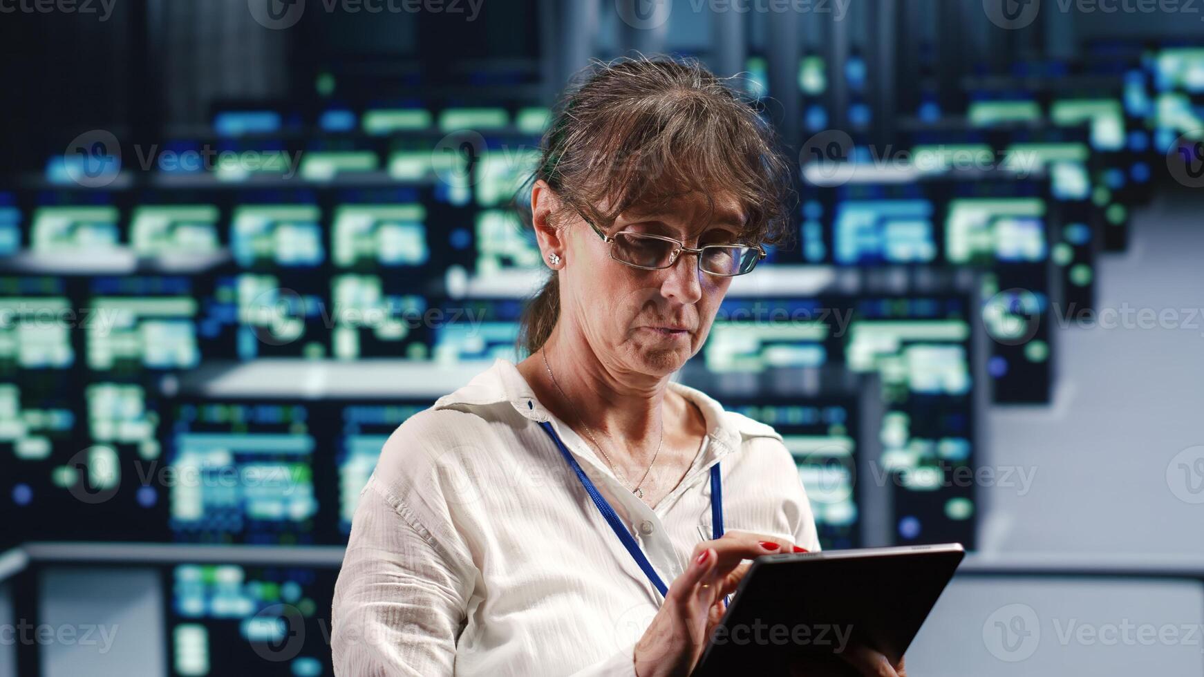 Skilled computer scientist in data center equipped to handle complex computing requirements, doing regular upgrades to server clusters, increasing processing power to prevent malfunctions photo