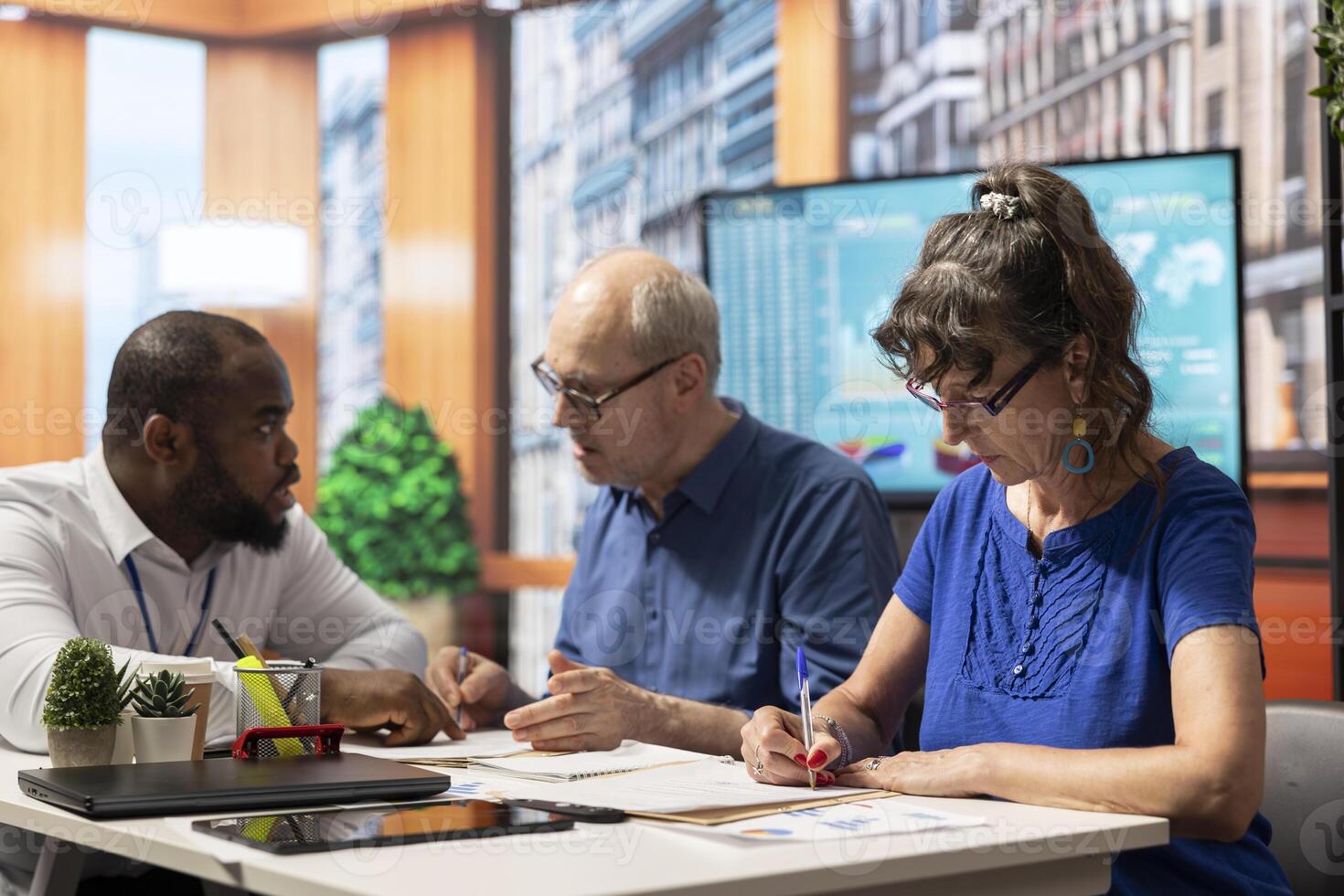 Elderly people signing the retirement plan contract in a meeting with adviser, choosing the perfect investment to secure their pension and future income. Sign the document terms. photo