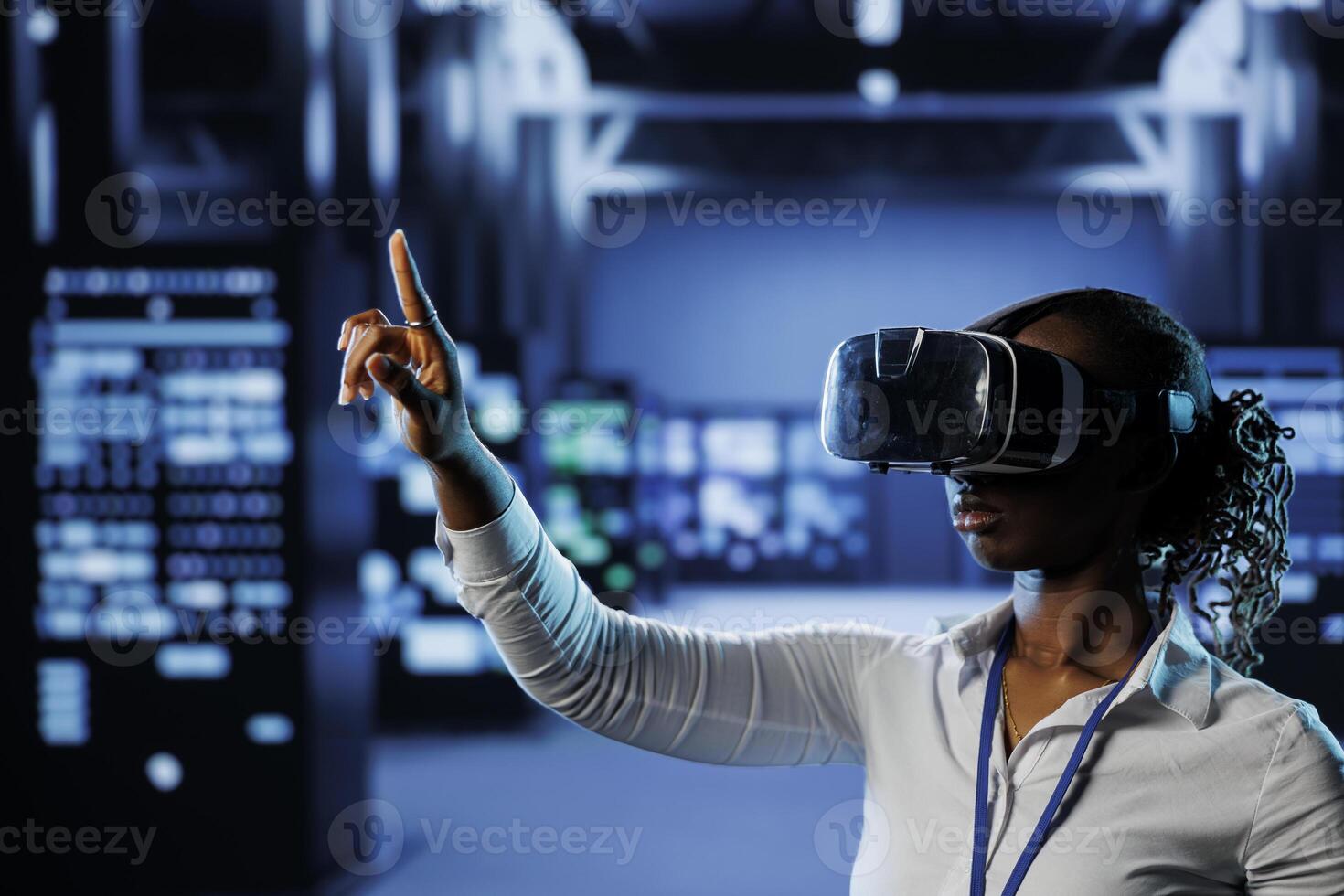 System administrator in data center uses virtual reality to prevent servers overload. Employee with VR simulation goggles in server room ensuring enough network bandwidth for smooth operations photo