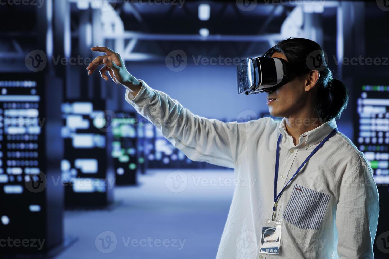 Licensed engineer in data center uses virtual reality to prevent system overload. Professional with VR goggles in server room ensuring enough network bandwidth for smooth operations photo