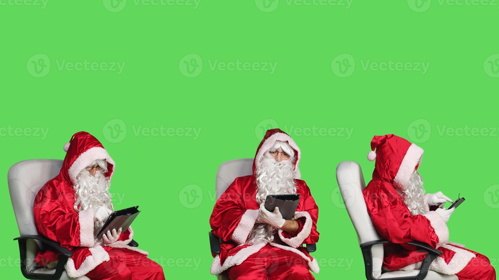 Saint nick works on tablet over greenscreen, browsing webpage online and preparing to celebrate christmas eve holiday. Young adult in santa claus famous costume using device sitting on chair. photo