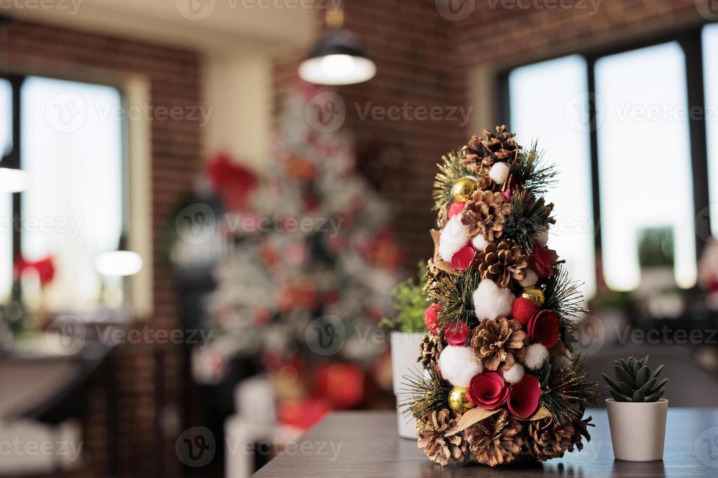 Small artificial christmas tree with ornaments and potted succulent in company office closeup. New year holiday season festive decor in corporate workplace with no people photo