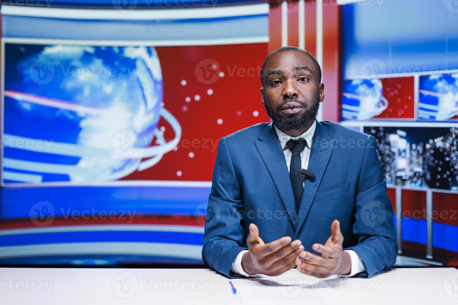News anchor man reading media papers, transmitting live information from exclusive sources to create latest news report. African american journalist presenting daily events and important topics. photo