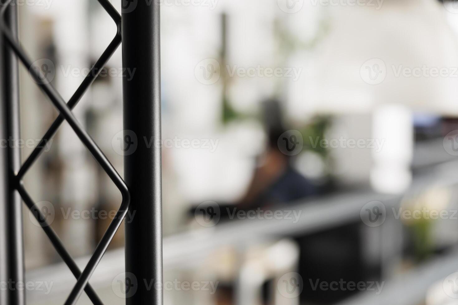 Blurred start up business office with employee working on background and metal rack close up. Company executive manager worker in modern coworking space workplace selective focus photo