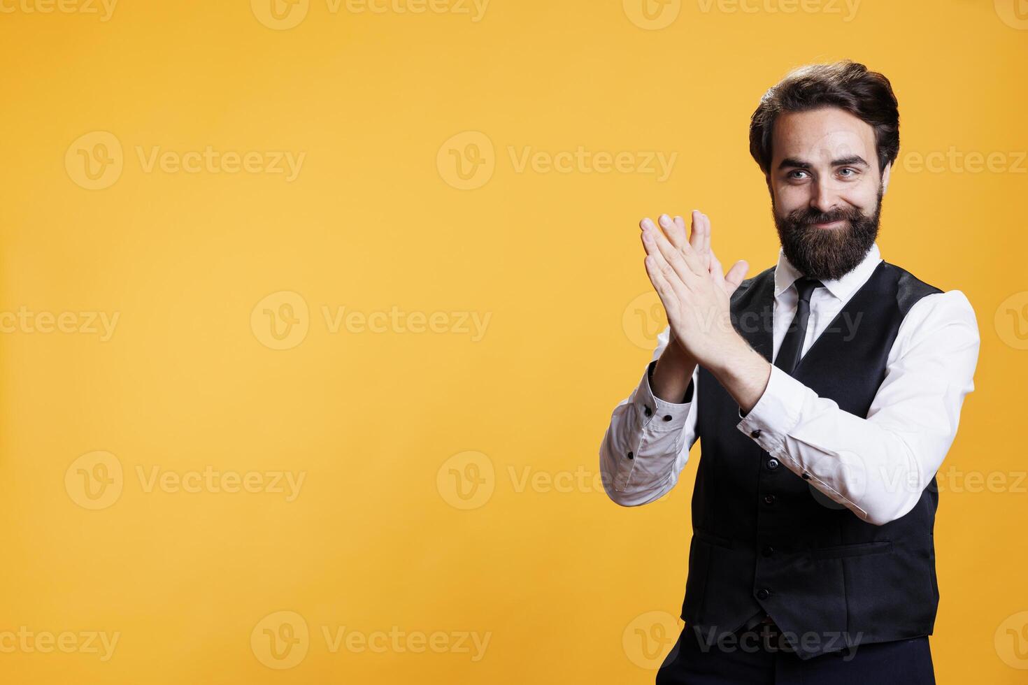 Positive employee clapping hands on camera, feeling happy after finding out about success. Young man with butler occupation applauding and giving confidence boost to person, cheering. photo
