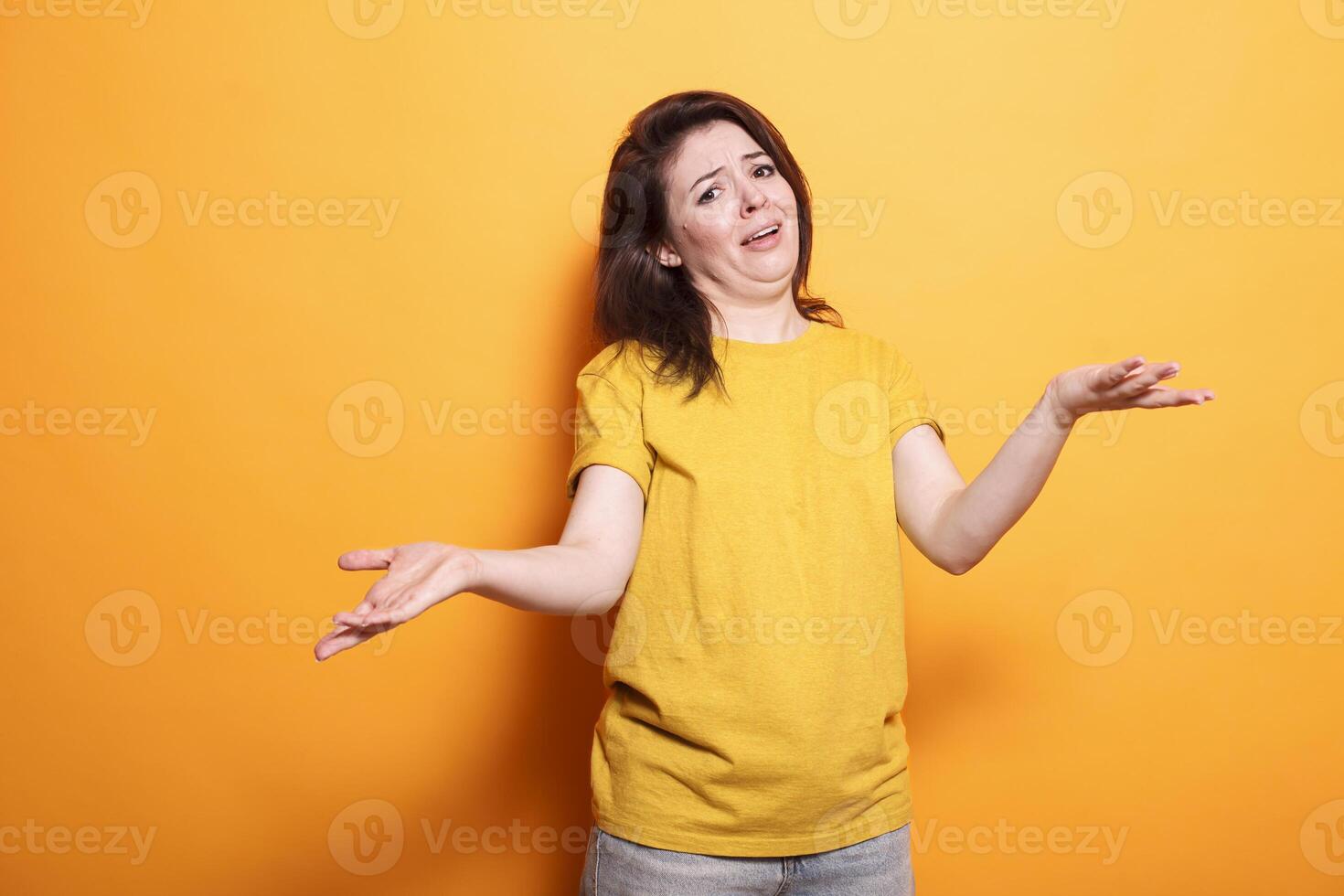 Portrait of clueless woman raising her hands and shoulders, unsure of the question. Caucasian lady with doubts is standing over isolated background with an uncertain and confused expression. photo