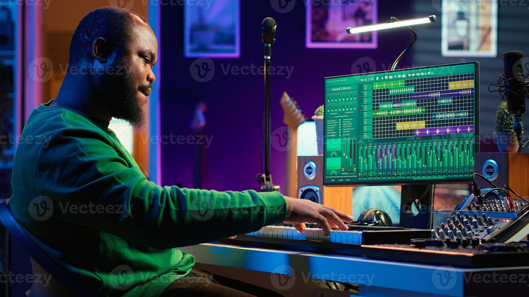 Artist playing piano electronic keyboard and recording new sounds, producing new midi controller notes in his home studio. Audio producer working with digital audio workstation software. Camera A. photo