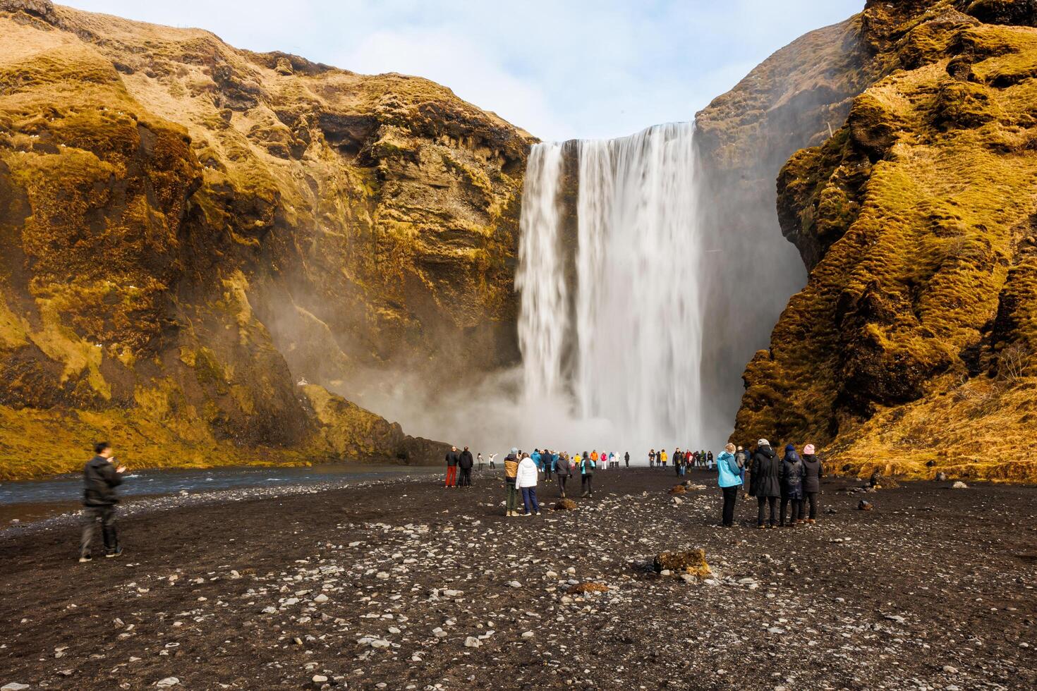 Nordic skgafoss waterfall circa March 2023, icelandic landscape with massive water stream cascade. Spectacular scandinavian river flowing down off of frozen hills, panoramic view. photo
