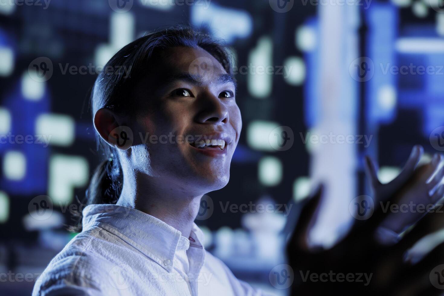 Happy citizen wandering around city streets at night, looking around to surrounding skyscrapers in metropolitan cityscape setting. Businessman leaving work, taking a walk outside empty urban landscape photo