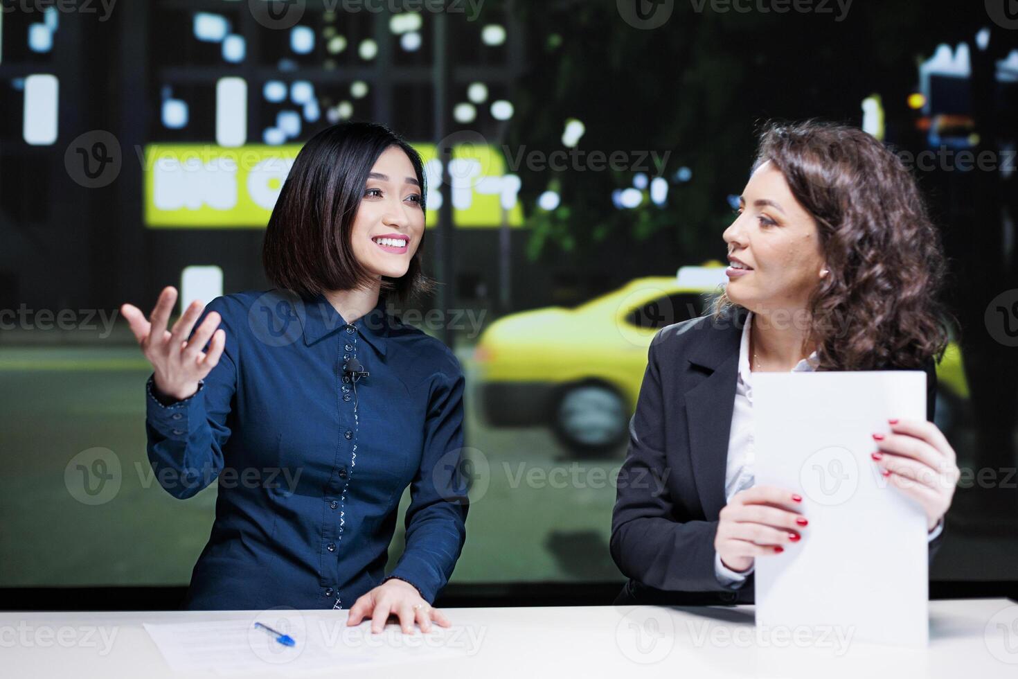 Journalists team open night show discussion in newsroom, delivering important topics with exclusive information. Diverse women presenting celebrity drama and creating tv content. photo