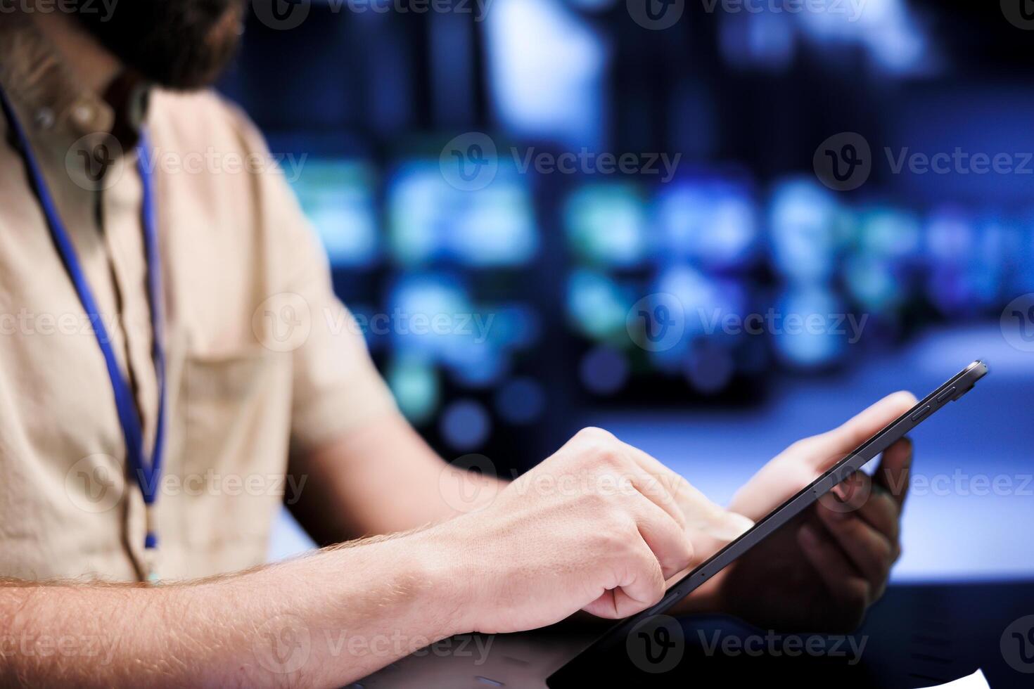 System administrator using tablet to examine server rows for power fluctuations, ensuring uninterrupted computing power. Manager monitoring high tech facility hardware, close up photo