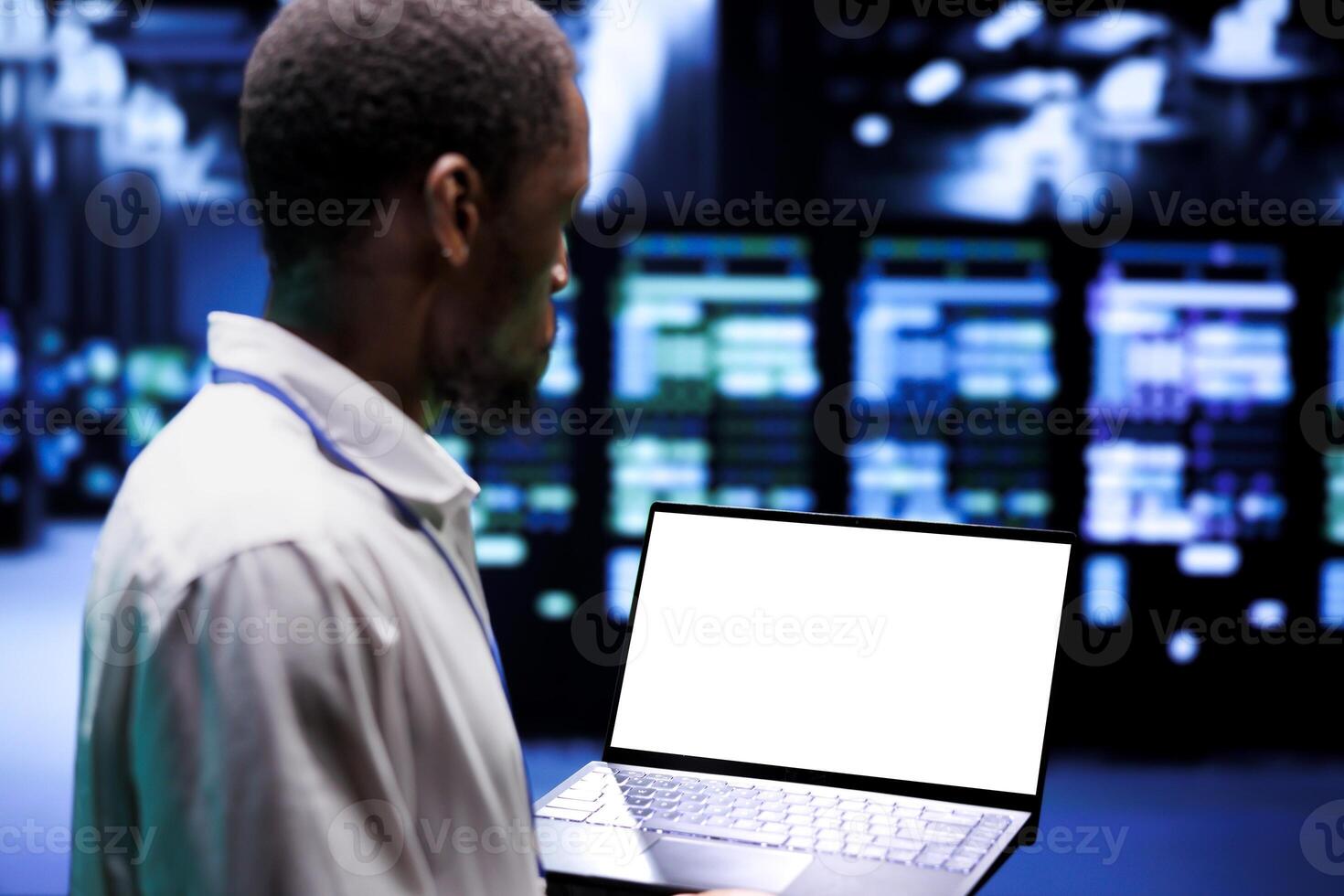Computer scientist inspecting blade servers doing intense computations. Programmer using mock up tablet to assess strain on high tech data center caused by AI applications driving up power usage photo