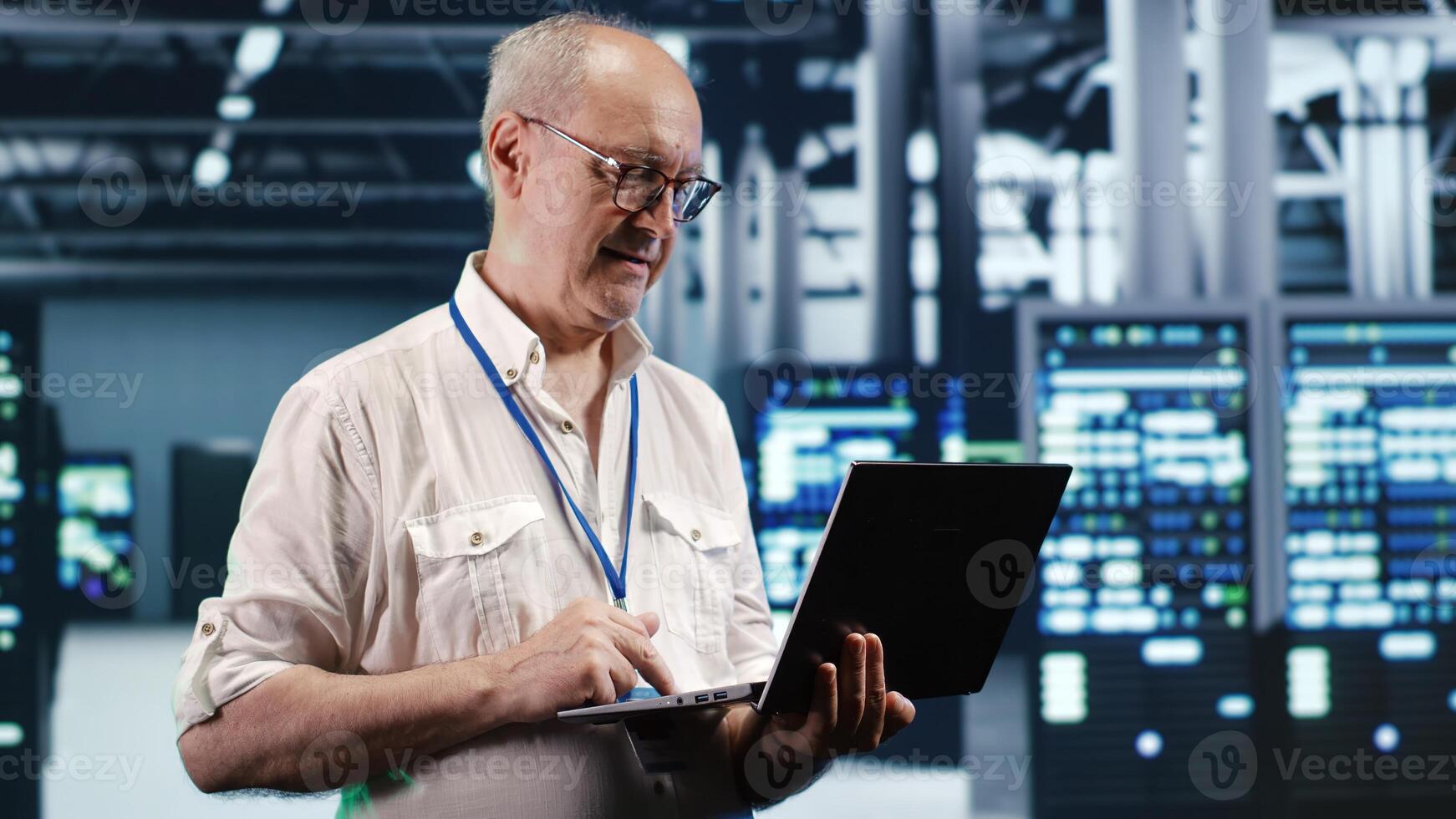Trained IT professional navigating network of servers in industrial place. Manager with laptop ensuring perfect operations, doing optimizations and maintenance in data center photo