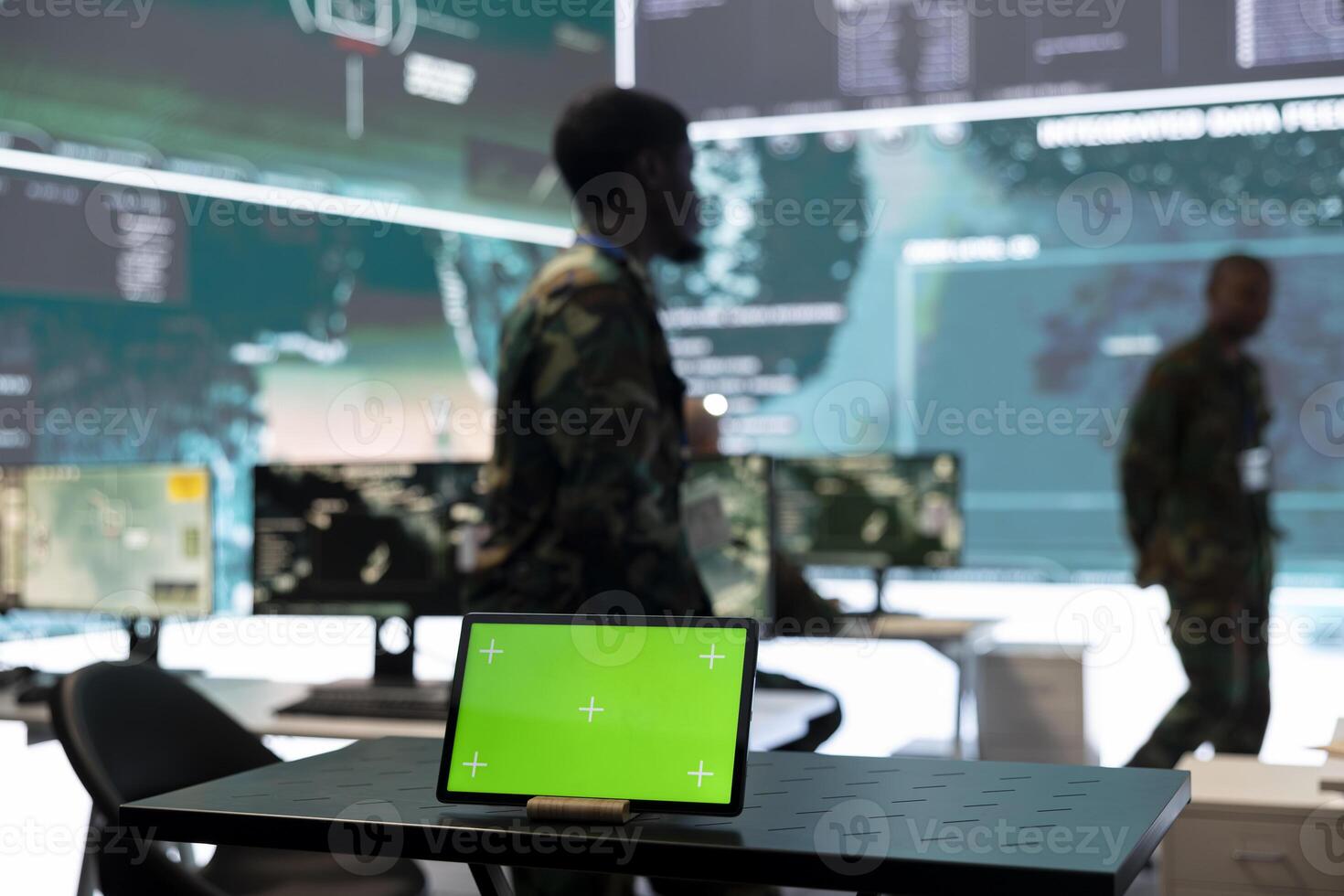 Tablet with green screen display running in a command center base of operations, army personnel ensuring national safety in monitoring room. Diverse soldiers use radar surveillance system. photo