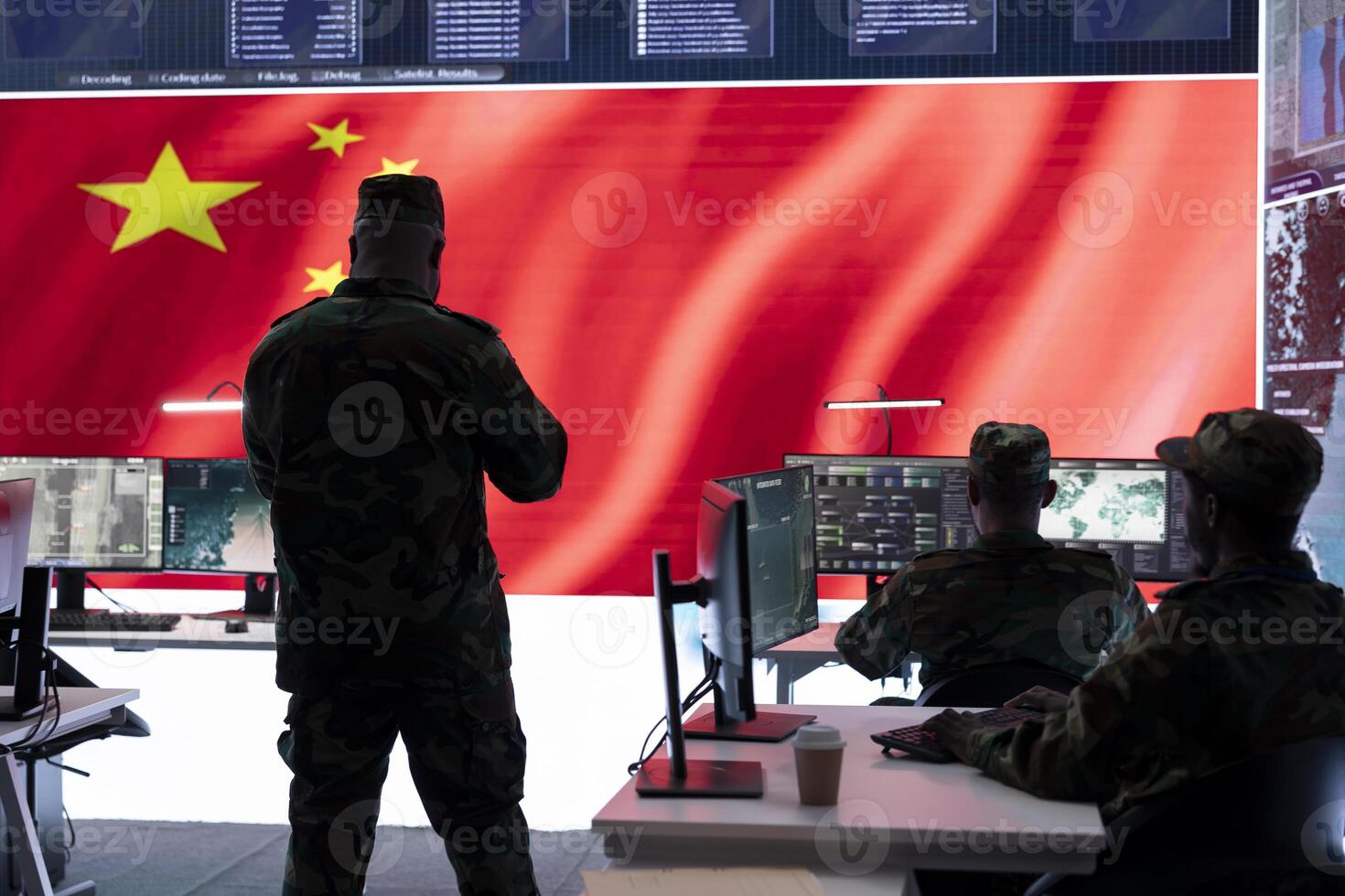 Military analyst reviews surveillance data on computer and big screen in Chinese military command post, spreading misinformation and inflicting fear among the population. Defense and security. photo