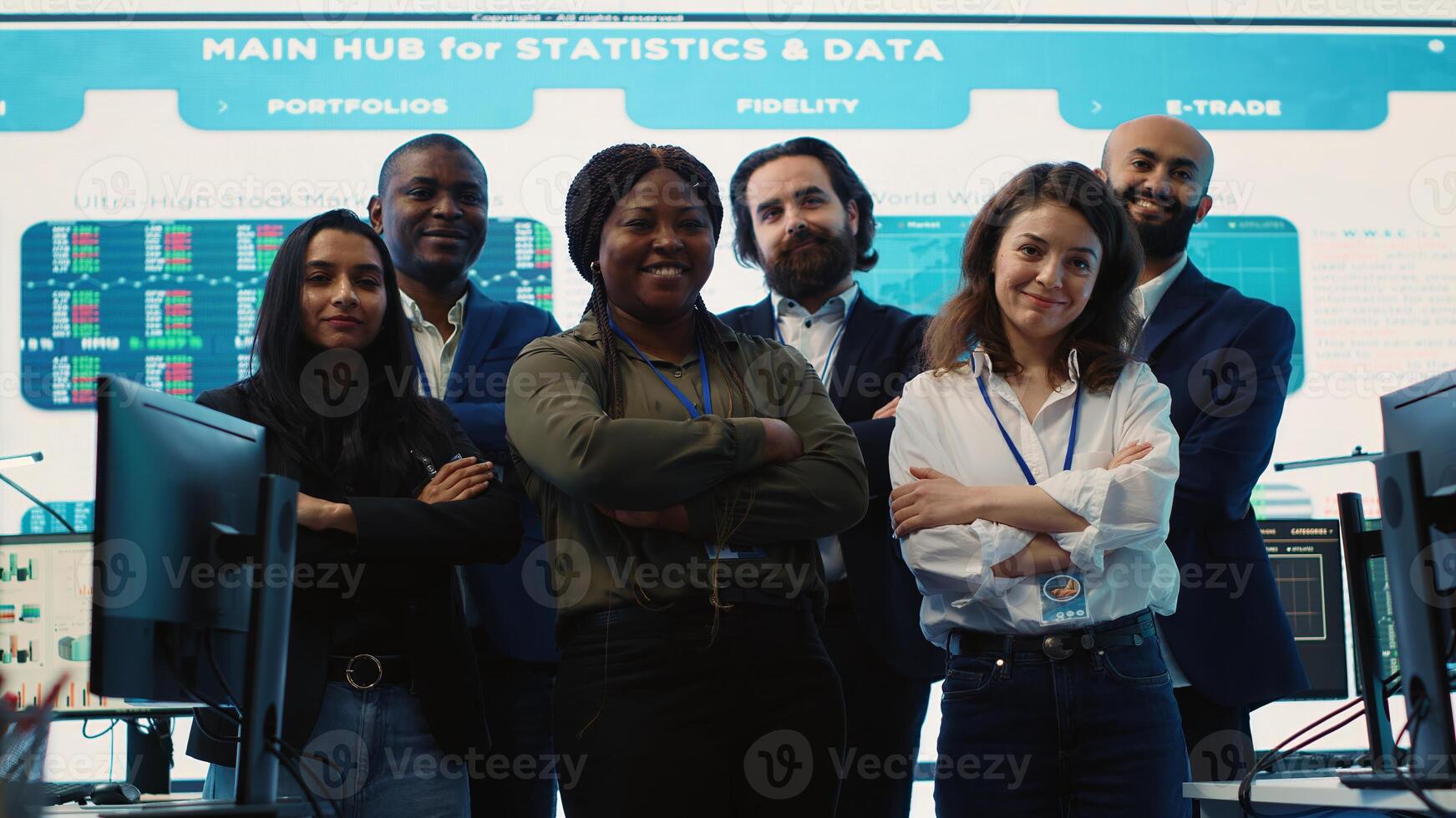 Diverse group of business professionals posing together in monitoring room, multinational company headquarters. Executive management team working with big data screen in the office. Camera A. photo