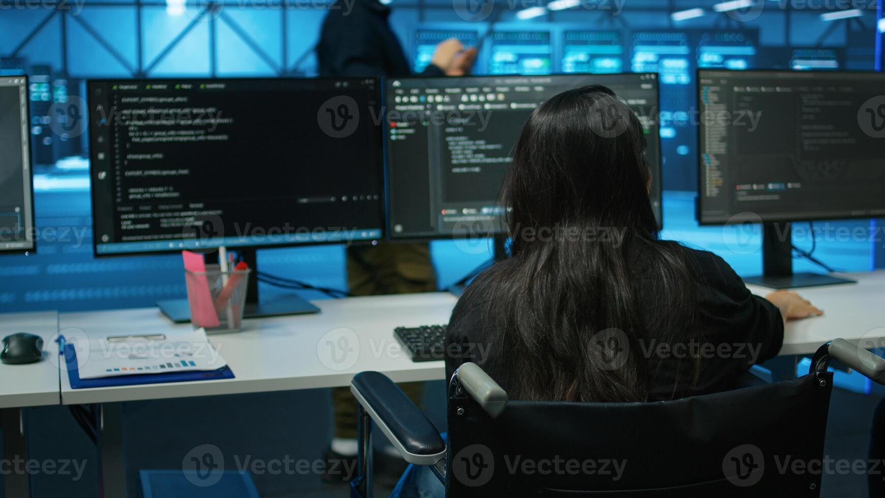 Woman with impairment in server farm looking over hardware parameters on clipboard files. Wheelchair user in data center reading paperwork, reviewing rigs performance photo