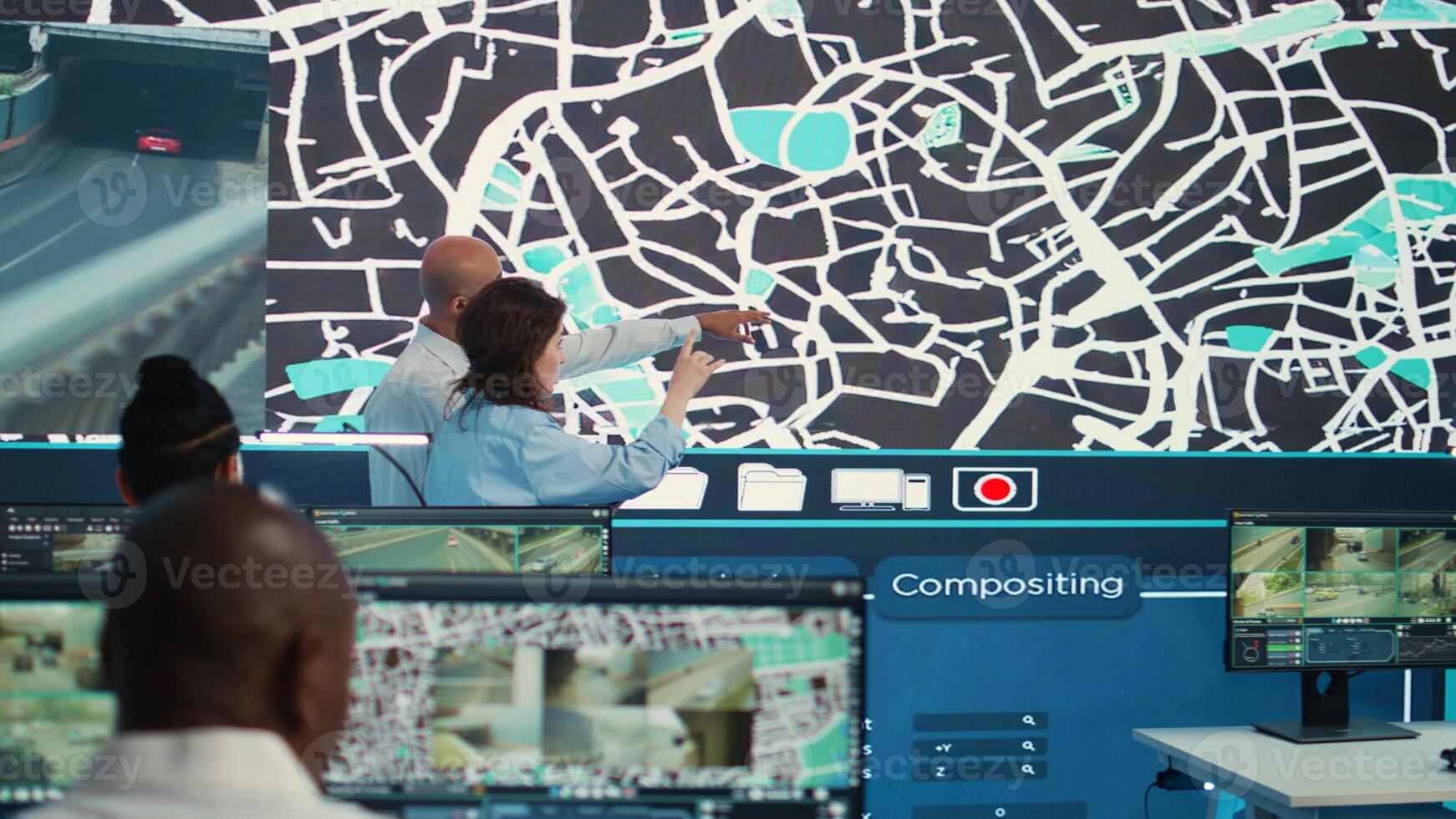 Diverse team of agency employees following delivery trucks via gps coordinates, working with CCTV surveillance footage and satellite map to ensure order shipping. Monitoring room. Camera B. photo