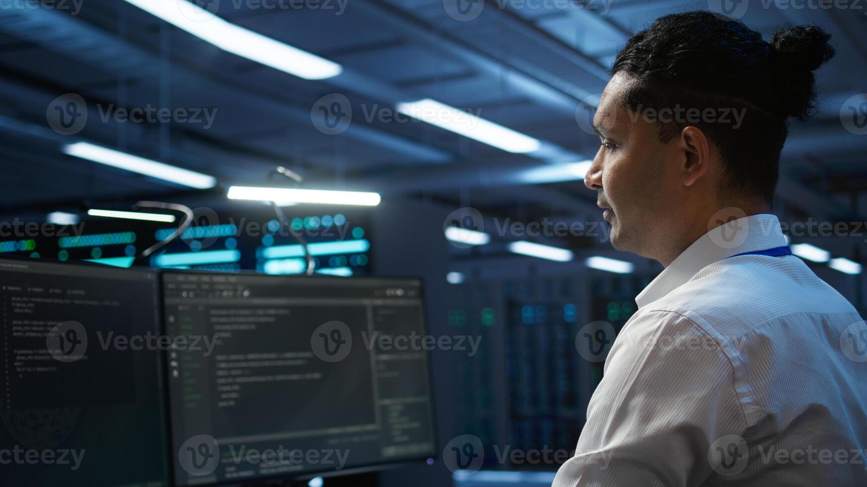 Data center system administrator responsible for installation of networking equipment solving tasks. IT employee at work doing maintenance on server room hardware, camera B photo