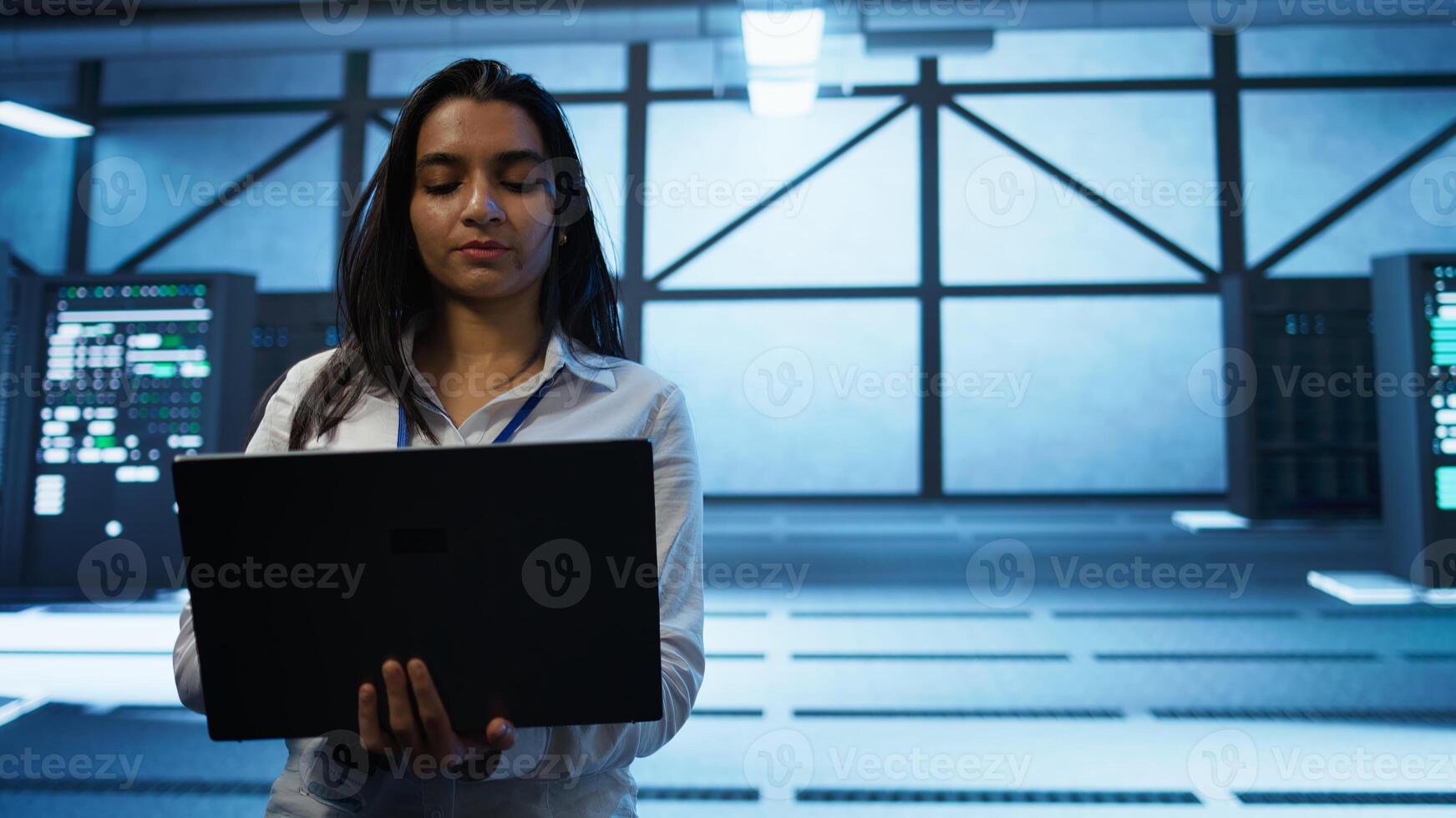 Admin in data center managing servers, operating systems and software programs. Tracking shot of woman in server hub ensuring networks are secure, up to date, and functioning properly, camera B photo