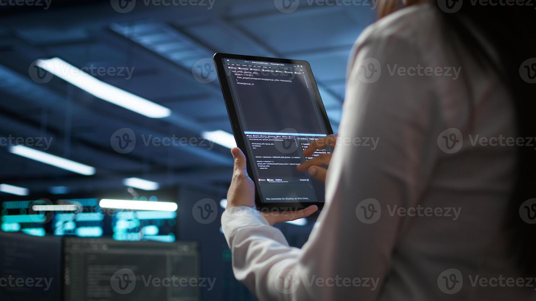 Data center software developer responsible for installation of networking equipment solving tasks on device. Close up of woman doing maintenance on server room infrastructure using tablet, camera B photo