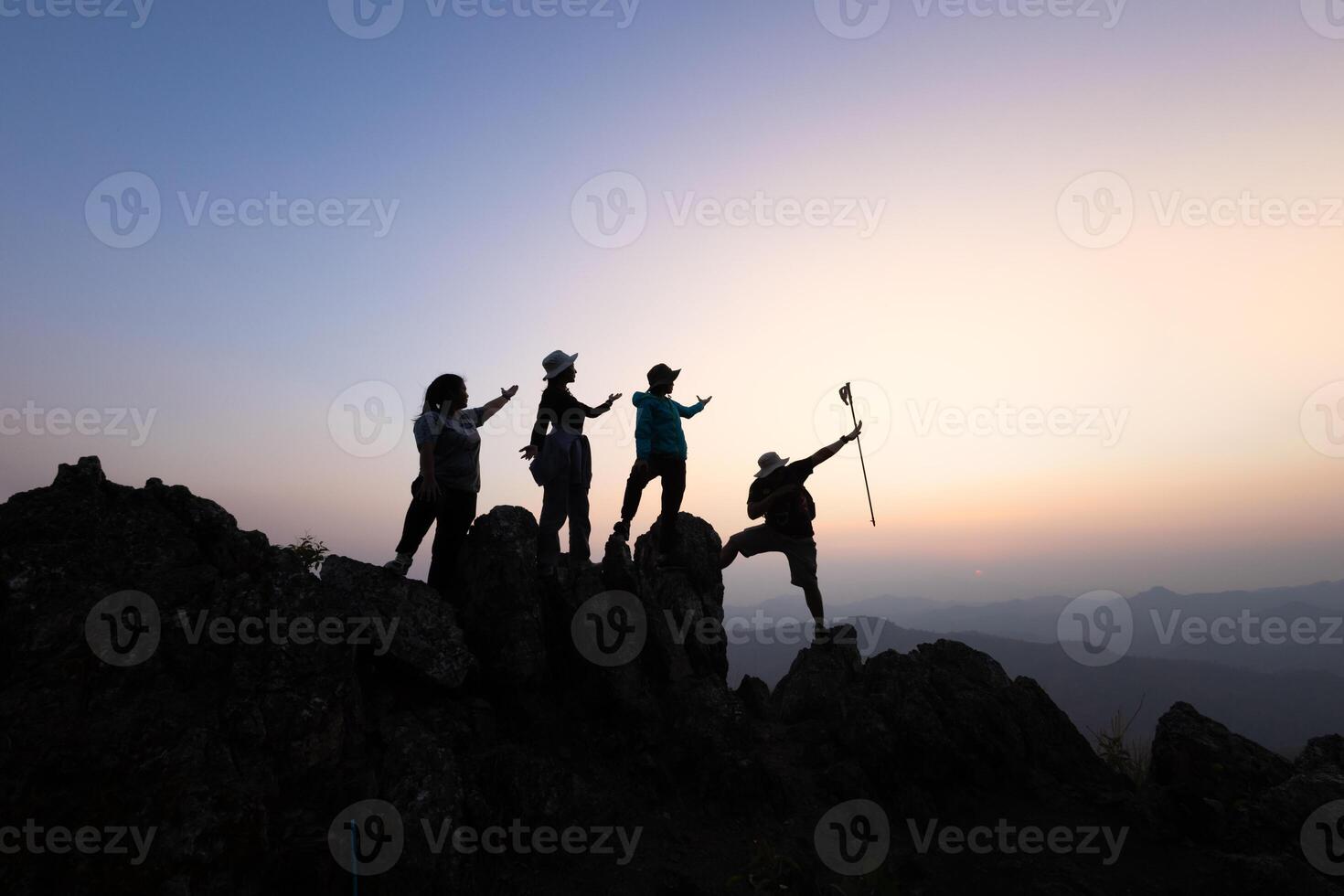 Silhouette of a group of climbers on a mountaintop. Success, teamwork and unity. photo