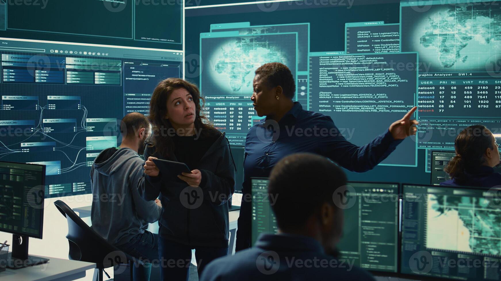 Cyber security experts women working on spyware and malware detection in a governmental agency. Examining server information on a big screen to combat cyberterrorism and cyberwarfare. Camera B. photo