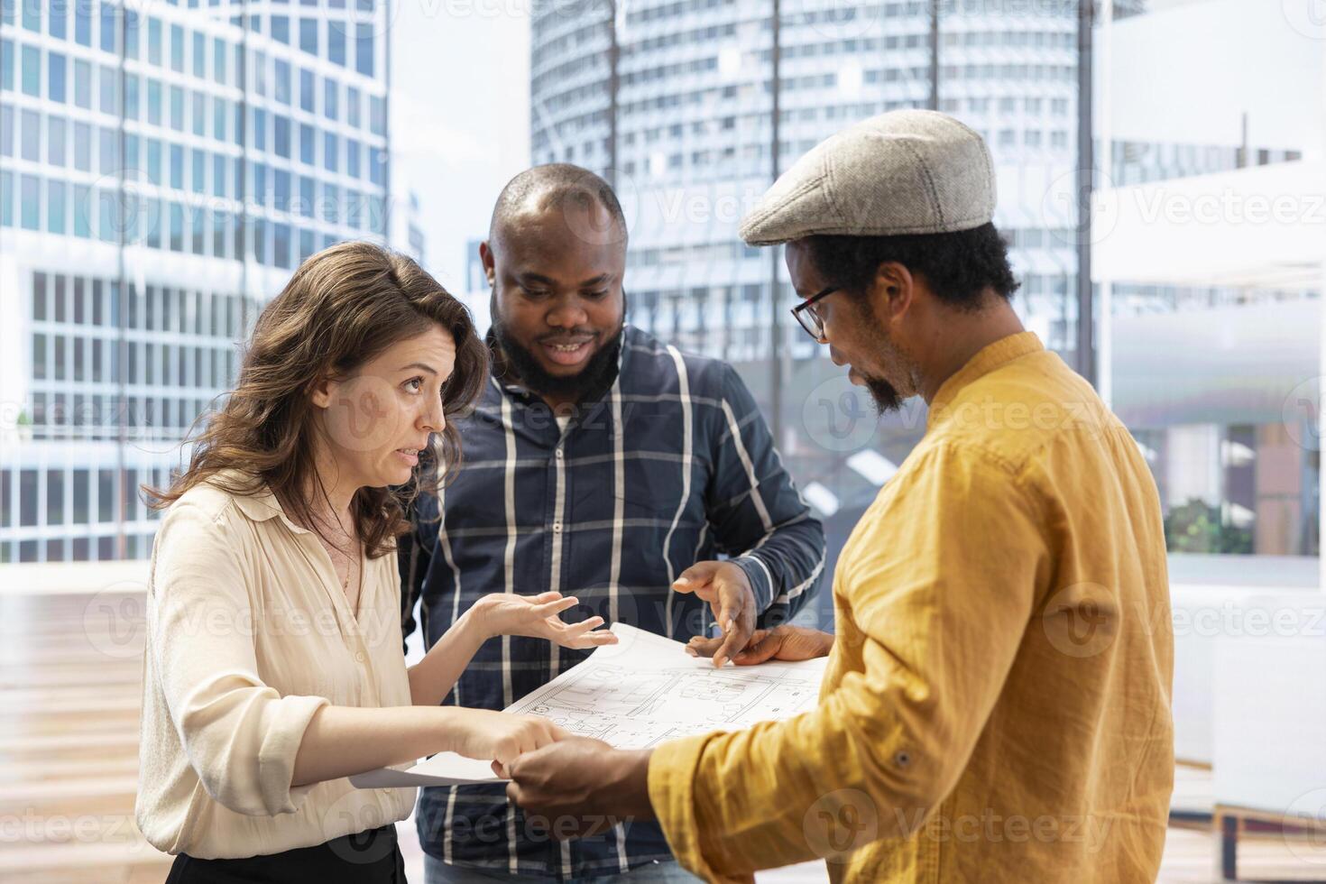 Corporate clients and realtor salesman evaluating blueprints and property layout during an office tour, planning leasing contract negotiations and investment strategy. Office relocation. photo