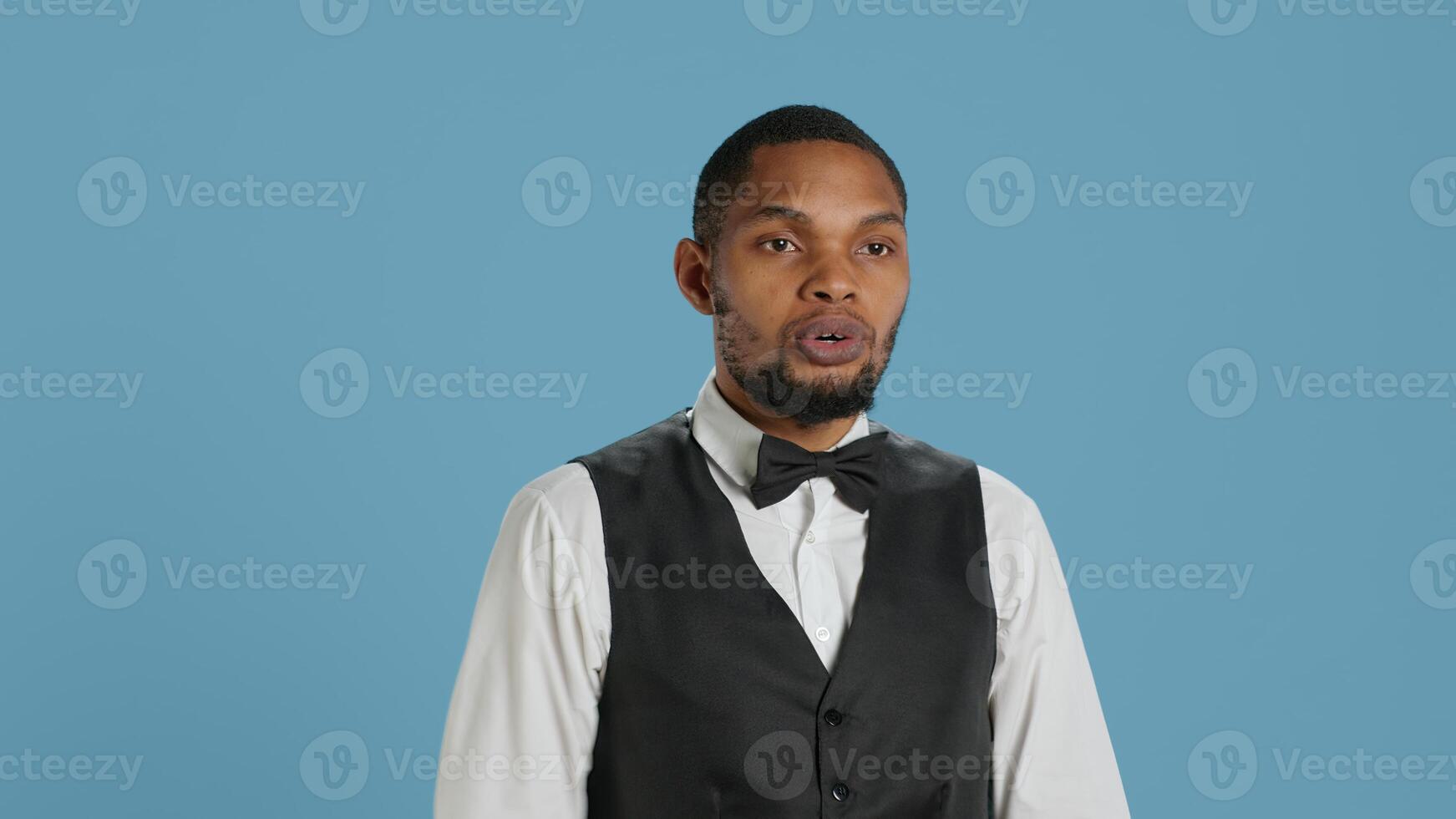Irritated hotel concierge staff expressing a stop sign and showing his disapproval abut something, doing rejection symbol. Negative employee refusing and rejecting a thing. Camera A. photo