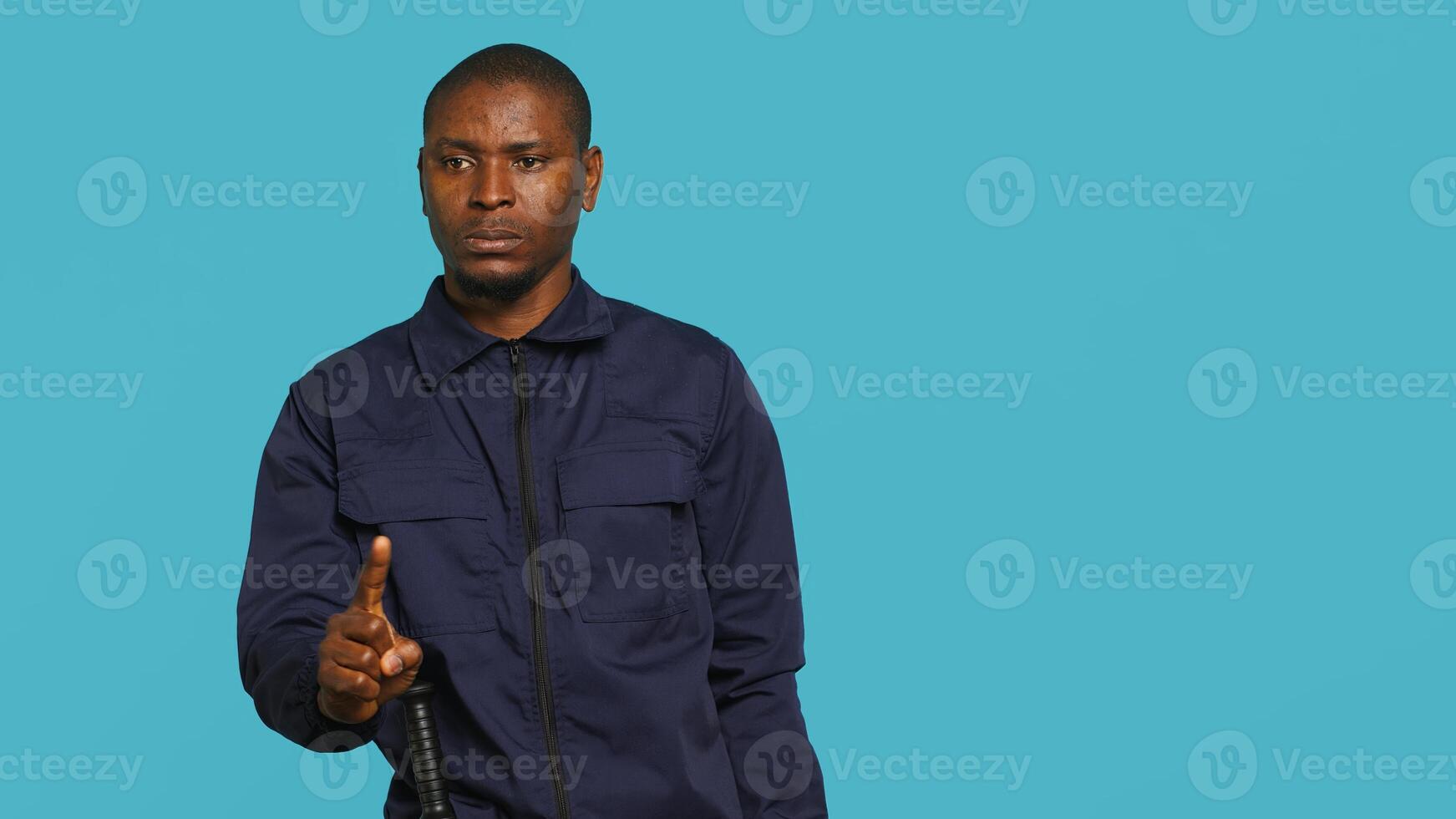 Portrait of security guard doing shush sign gesturing with finger to intruder while overseeing premises. Private law enforcement worker urging people to keep quiet, studio backdrop, camera A photo