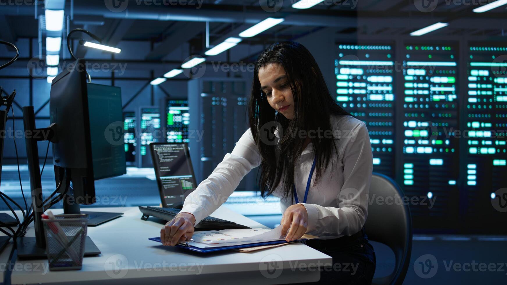 Engineer in data center installing software on computer, helping maintain network, troubleshooting arising issues. IT expert in server room establishing performance benchmarks, camera B photo