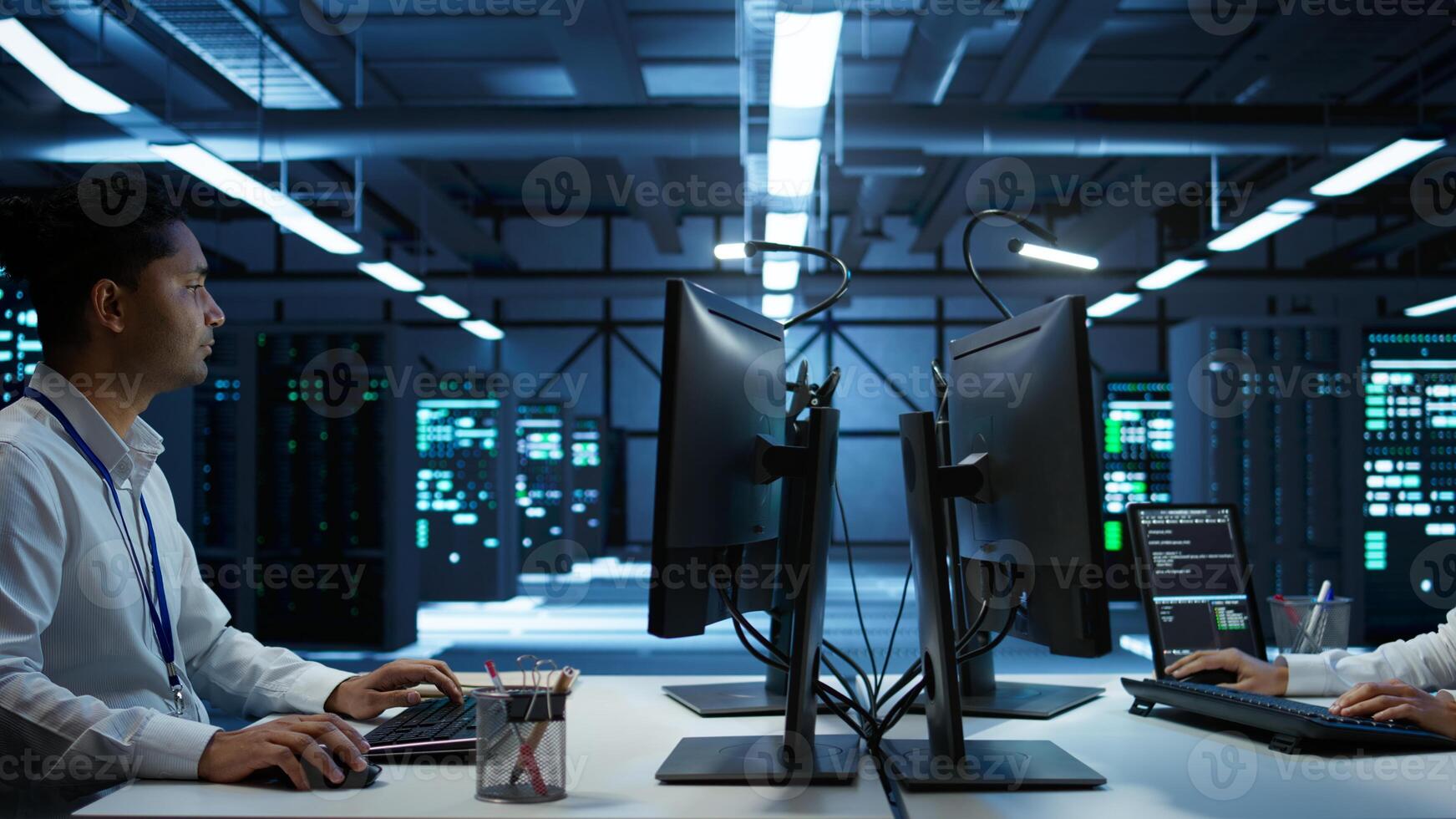Admin does maintenance on server hub to optimize it for data processing requirements of artificial intelligence workloads. Expert inspects data center used for machine learning, camera B photo
