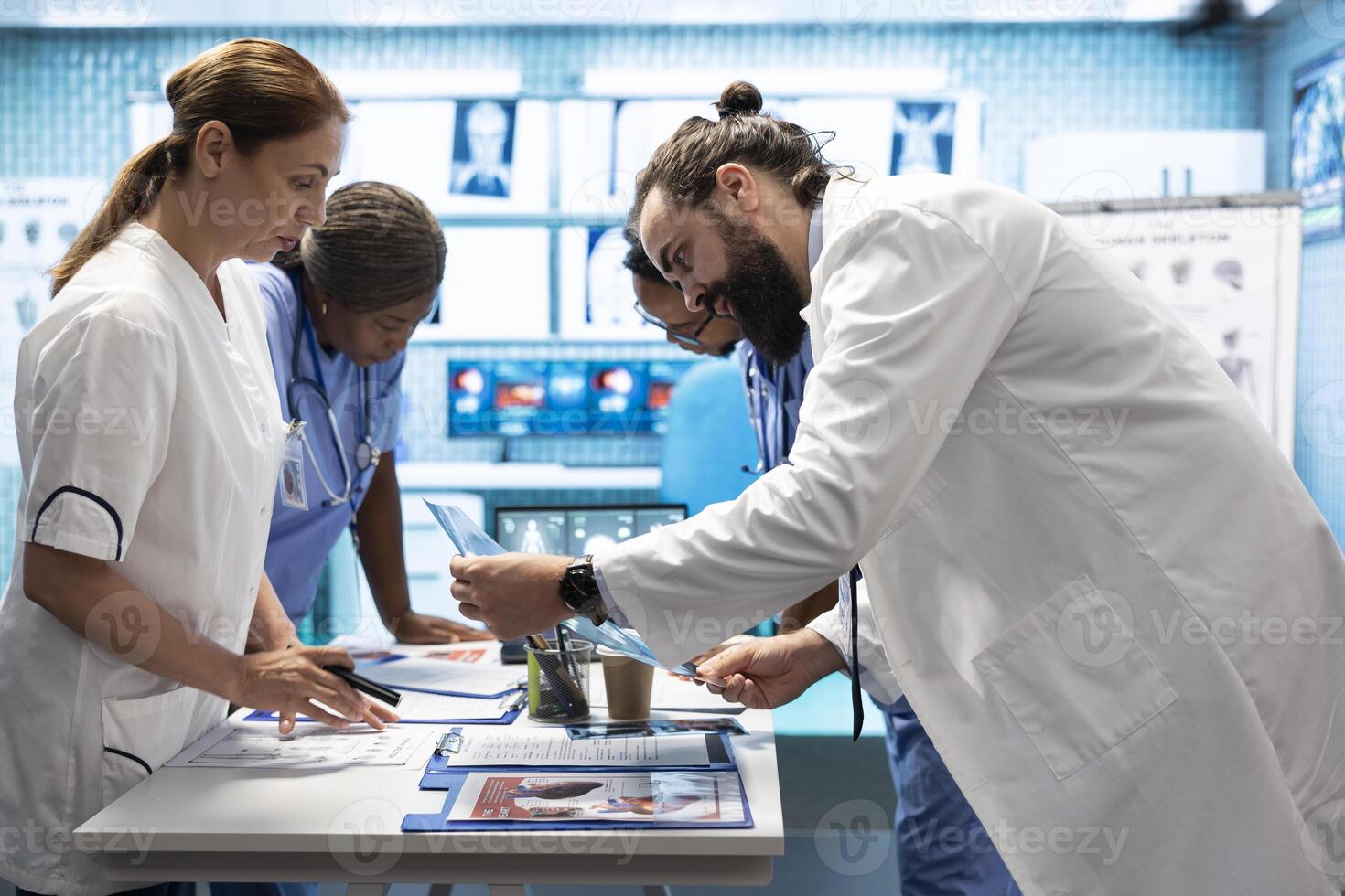 Medic discuss human anatomy scans in a radiology diagnostic meeting at a treatment center, teamwork and expertise in analyzing x ray results. Doctors examine hospital records and analytics. photo