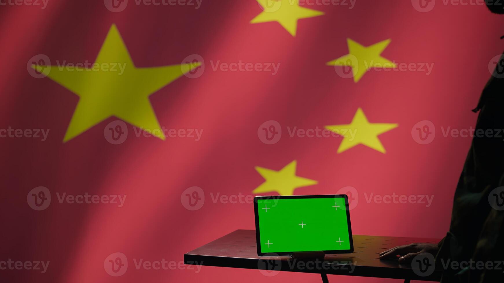 Chinese intelligence agency operator using green screen tablet to do mass propaganda on internet. CCP government secret agent engaging in psychological operations with mockup device, camera B photo