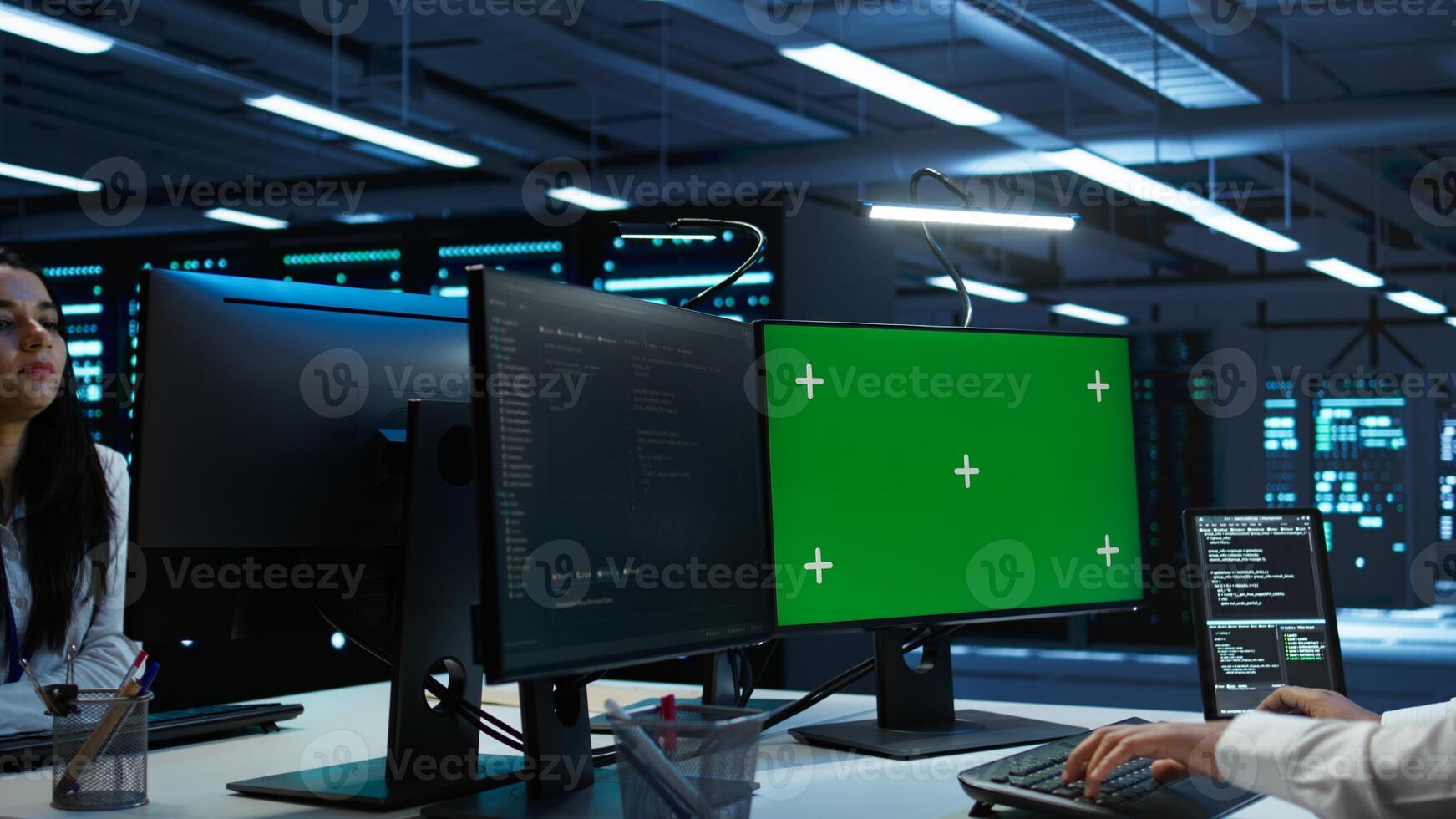 System administrator in data center installing software on isolated screen PC, troubleshooting issues. Admin uses mockup computer in server hub, establishing performance benchmarks, camera B photo