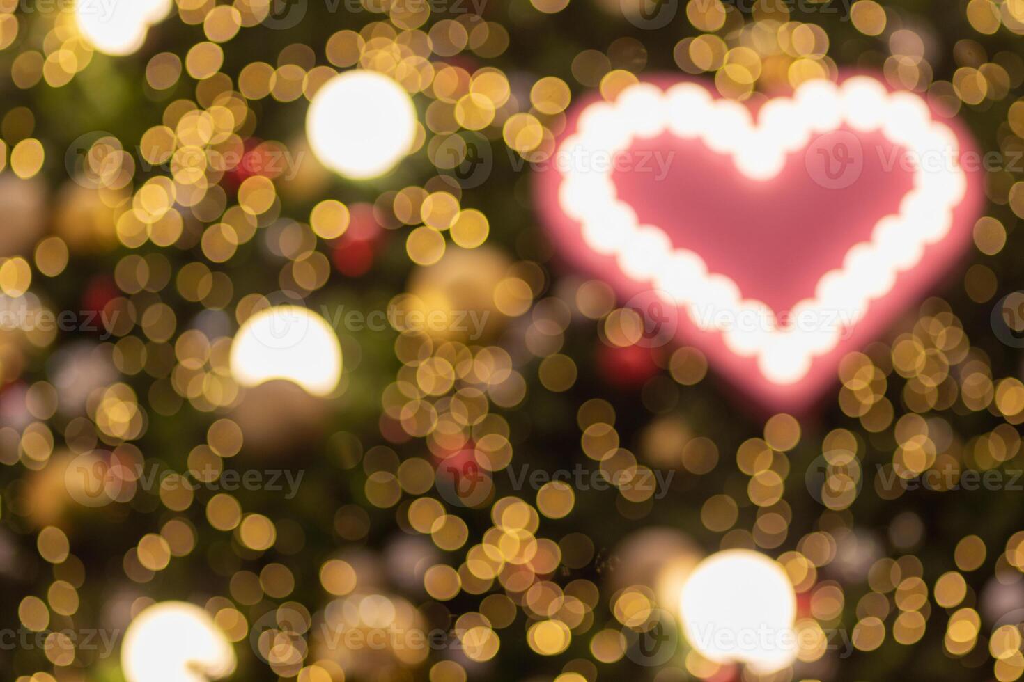 Blurred background, heart-shaped bokeh lights on the Christmas tree are beautifully decorated and the heart symbol signifies love, friendship and kindness. heart shaped lights abstract background photo