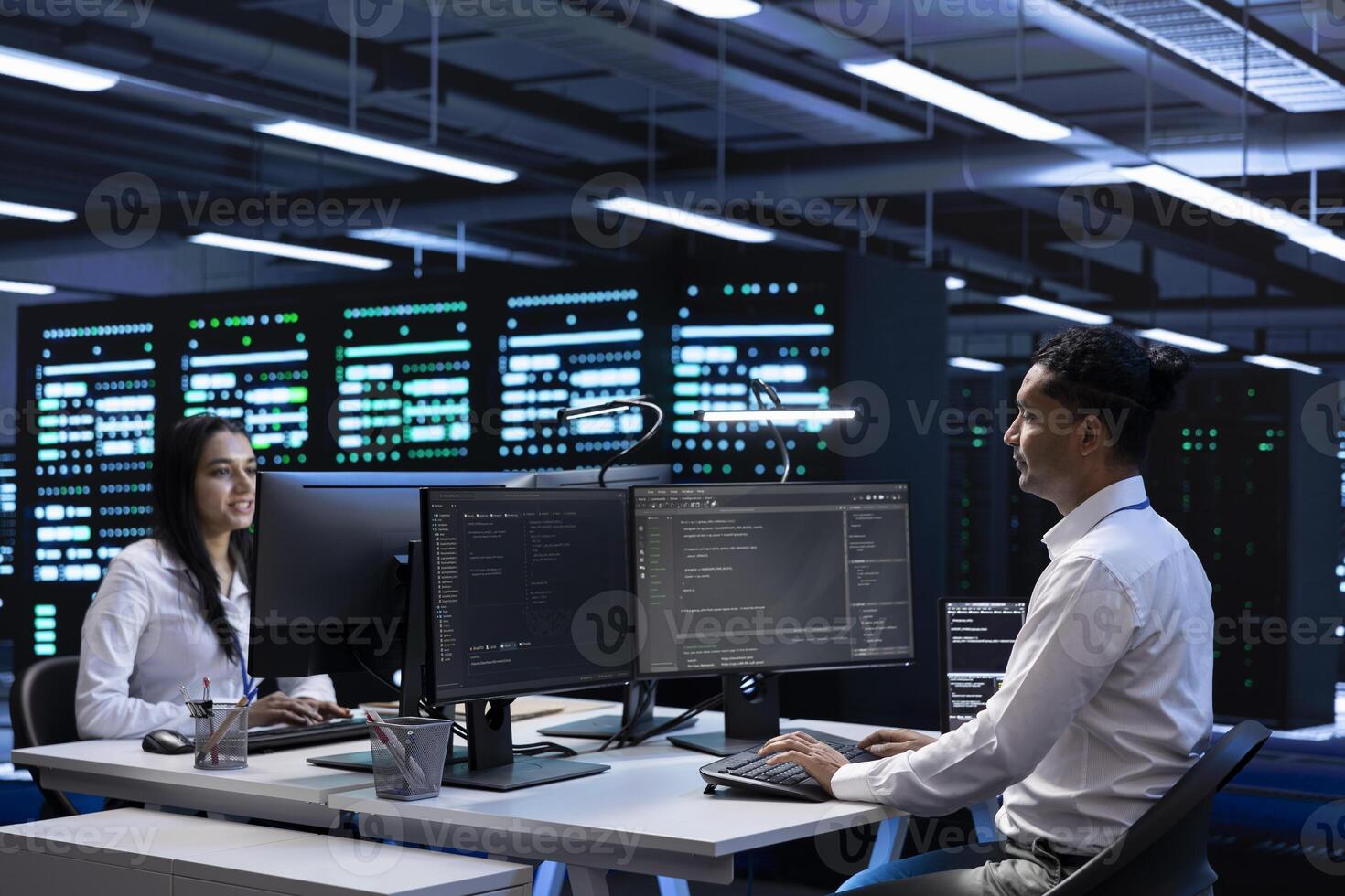 Team of technicians in data center checking equipment performance on computer after upgrading infrastructure. Teamworking IT staff members doing maintenance on storage arrays in servers room photo