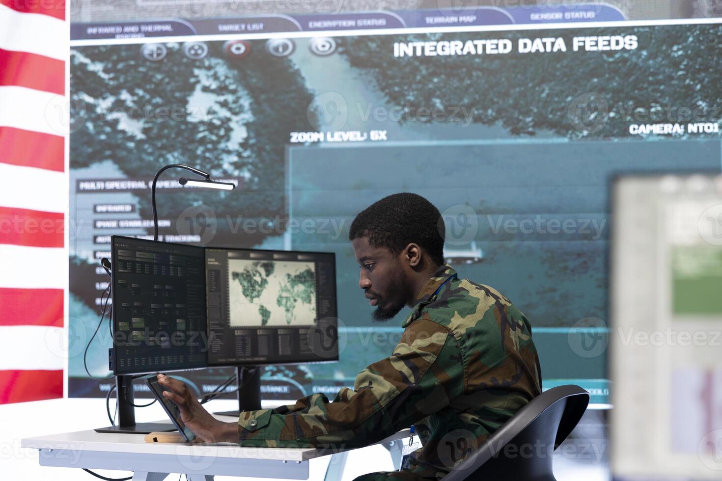 American military officer works in a high tech command post, managing national safety operations with the surveillance systems. Examining data for intelligence gathering. photo