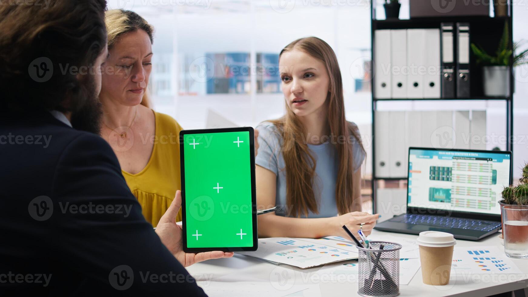 People receiving personalized financial plan from financial advisor using isolated screen tablet. Customers learn how to make profitable decisions from agent using chroma key device, camera A photo