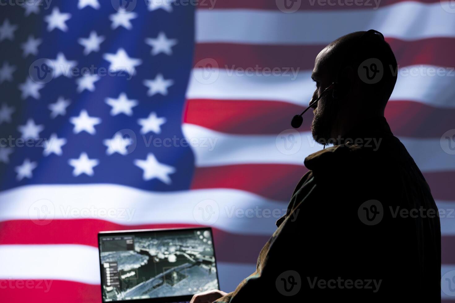 United States army dispatcher using headphones microphone, offering information to commanders fighting on front lines. NATO soldier providing intel for troops, isolated over USA flag photo