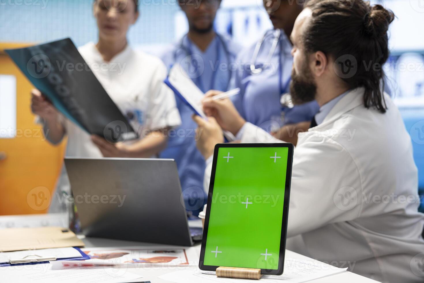 Licensed doctor and his staff review x ray scan results next to isolated copy space screen, examining hospital records before putting a diagnosis. Consulting analytics and radiography. photo