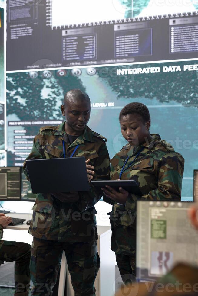 Soldiers team managing air traffic control for military aircrafts within the coastal area, using CCTV radar surveillance system. Troopers providing instructions such as flight plan data. photo